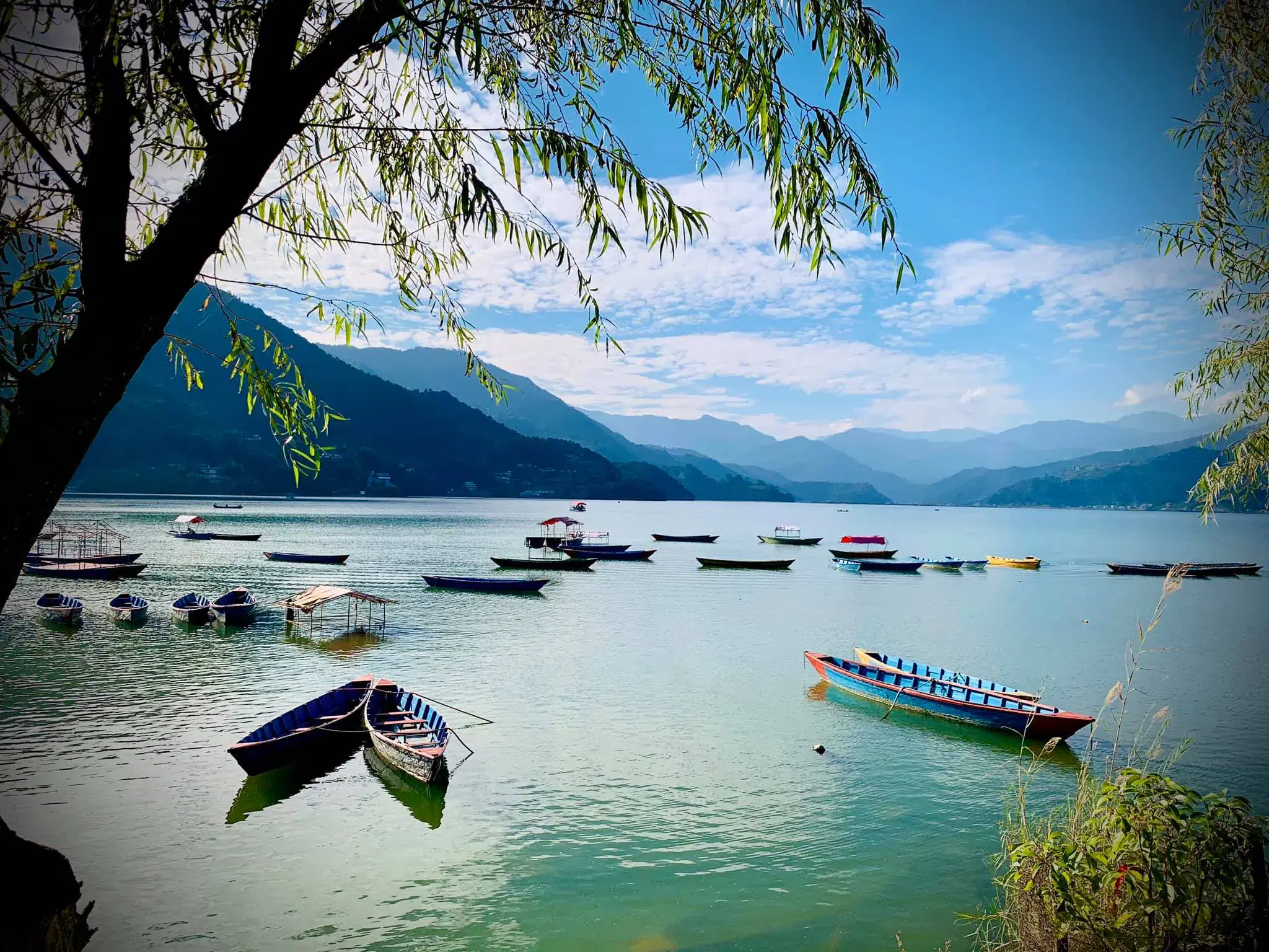 Mountain landscape featuring rocky terrain, water, and cloudy sky.