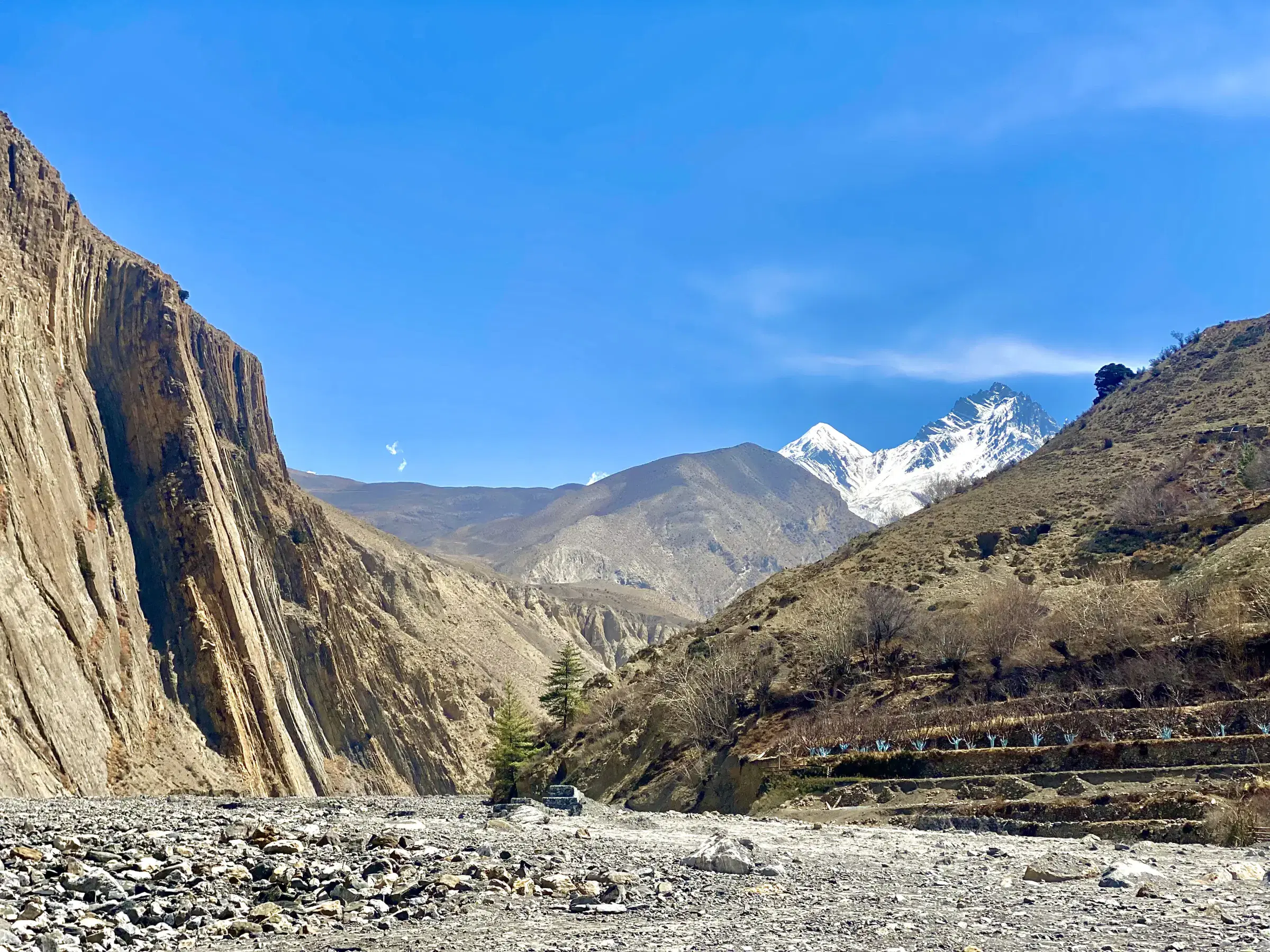 Mountain landscape featuring snowy terrain, a built structure, and cloudy sky.