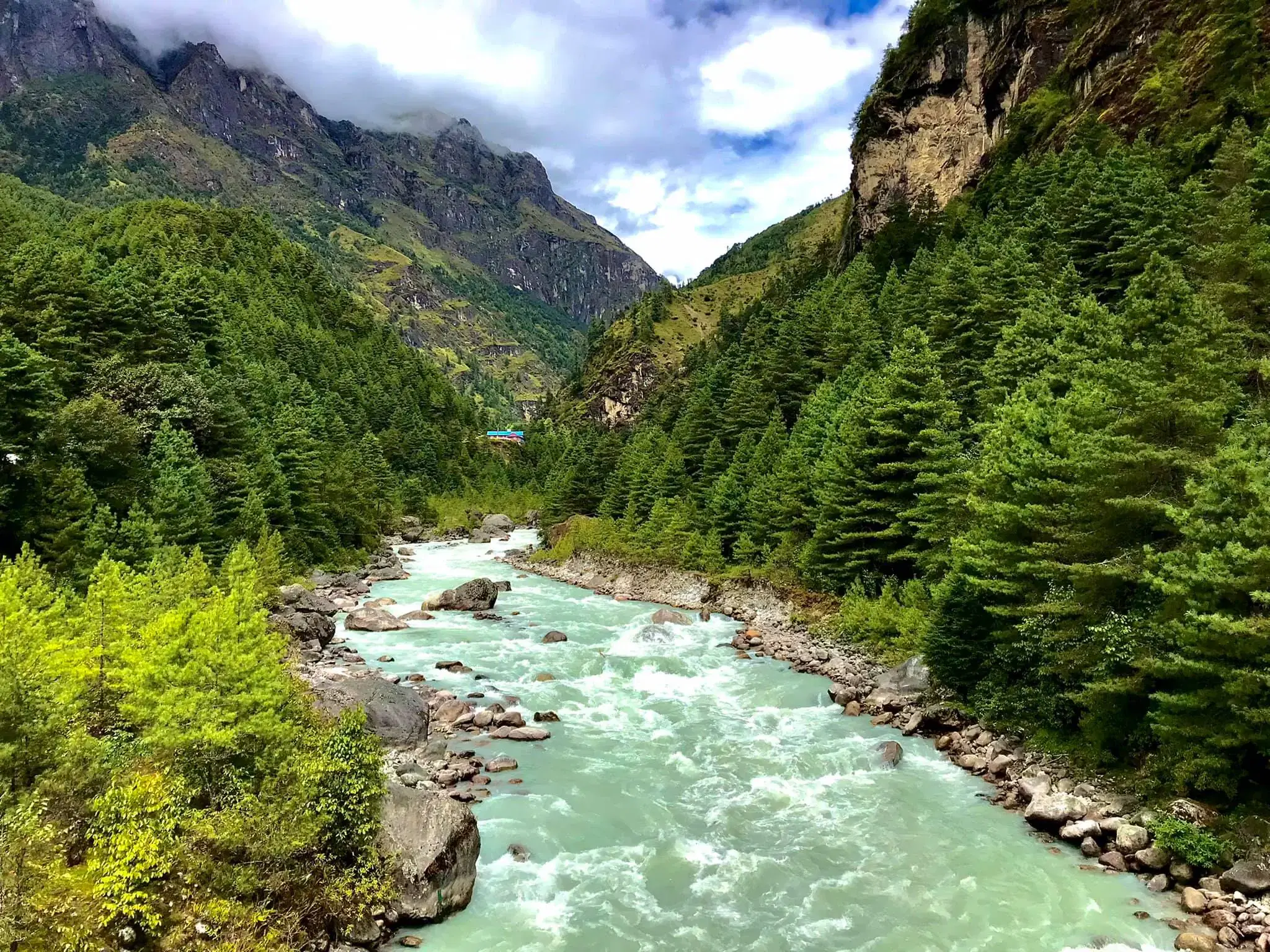 Mountain landscape featuring rocky terrain, water, and cloudy sky.