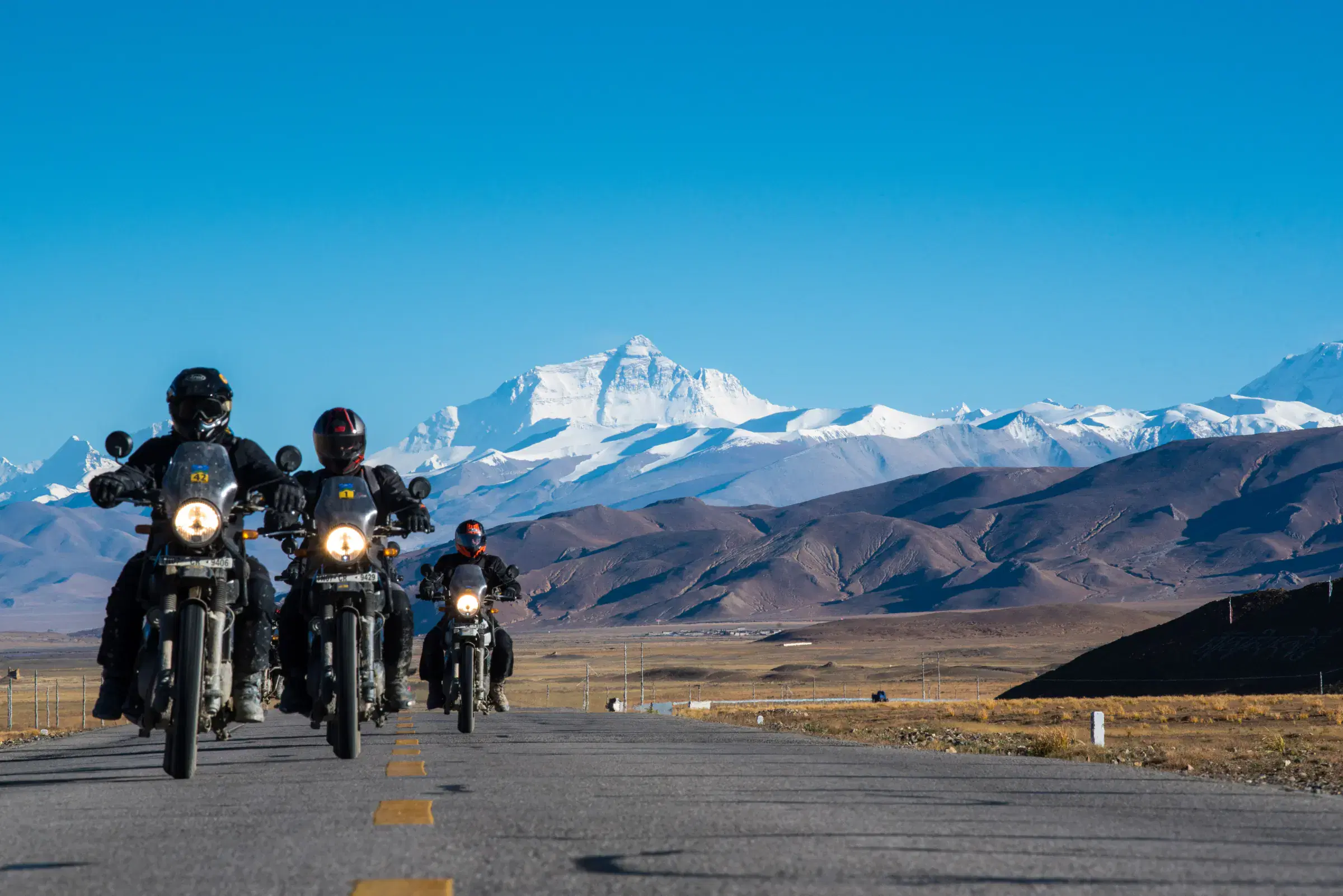 Outdoor scene featuring people, snowy terrain, and blue sky.