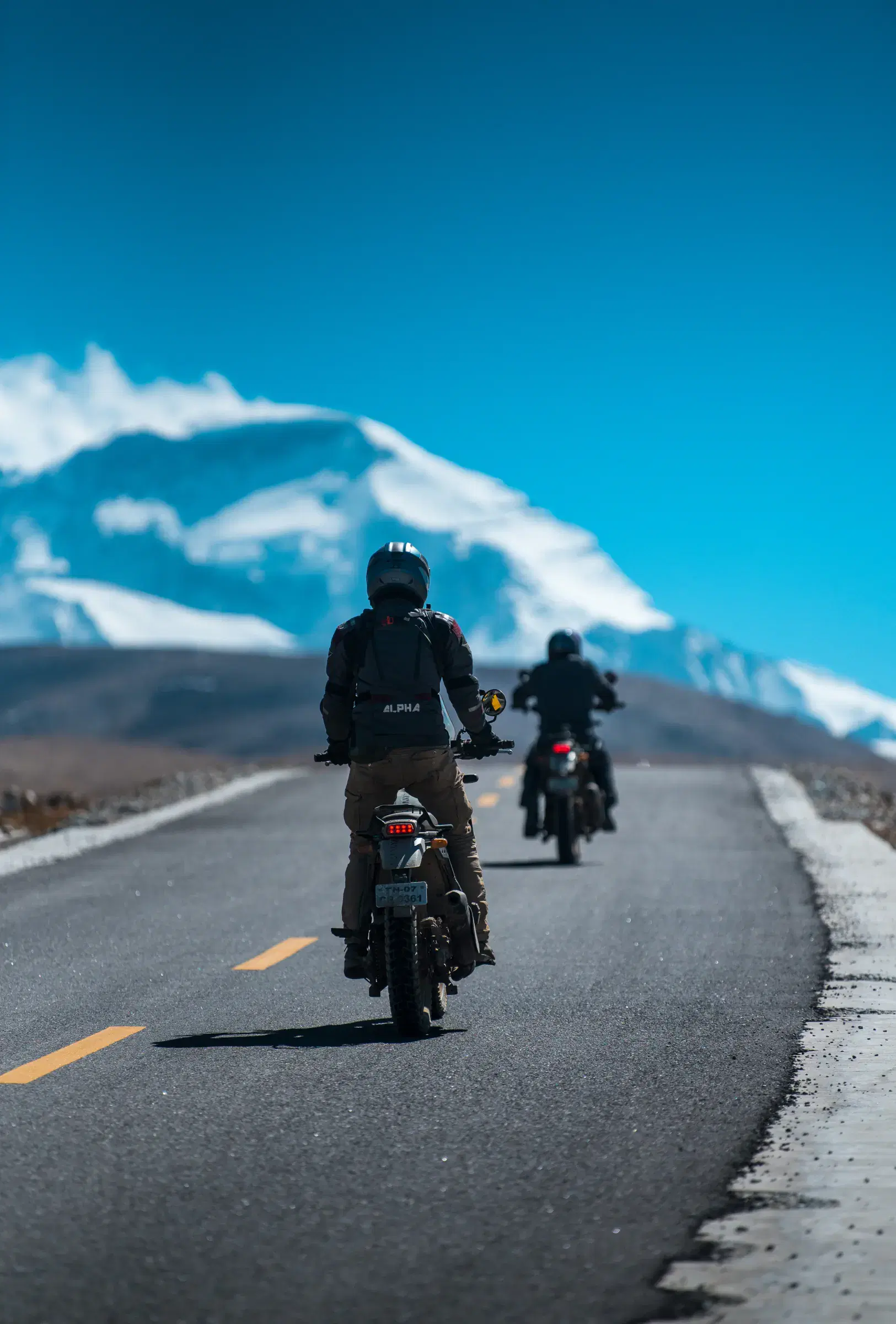 Portrait-oriented Outdoor scene featuring people, water, and blue sky.