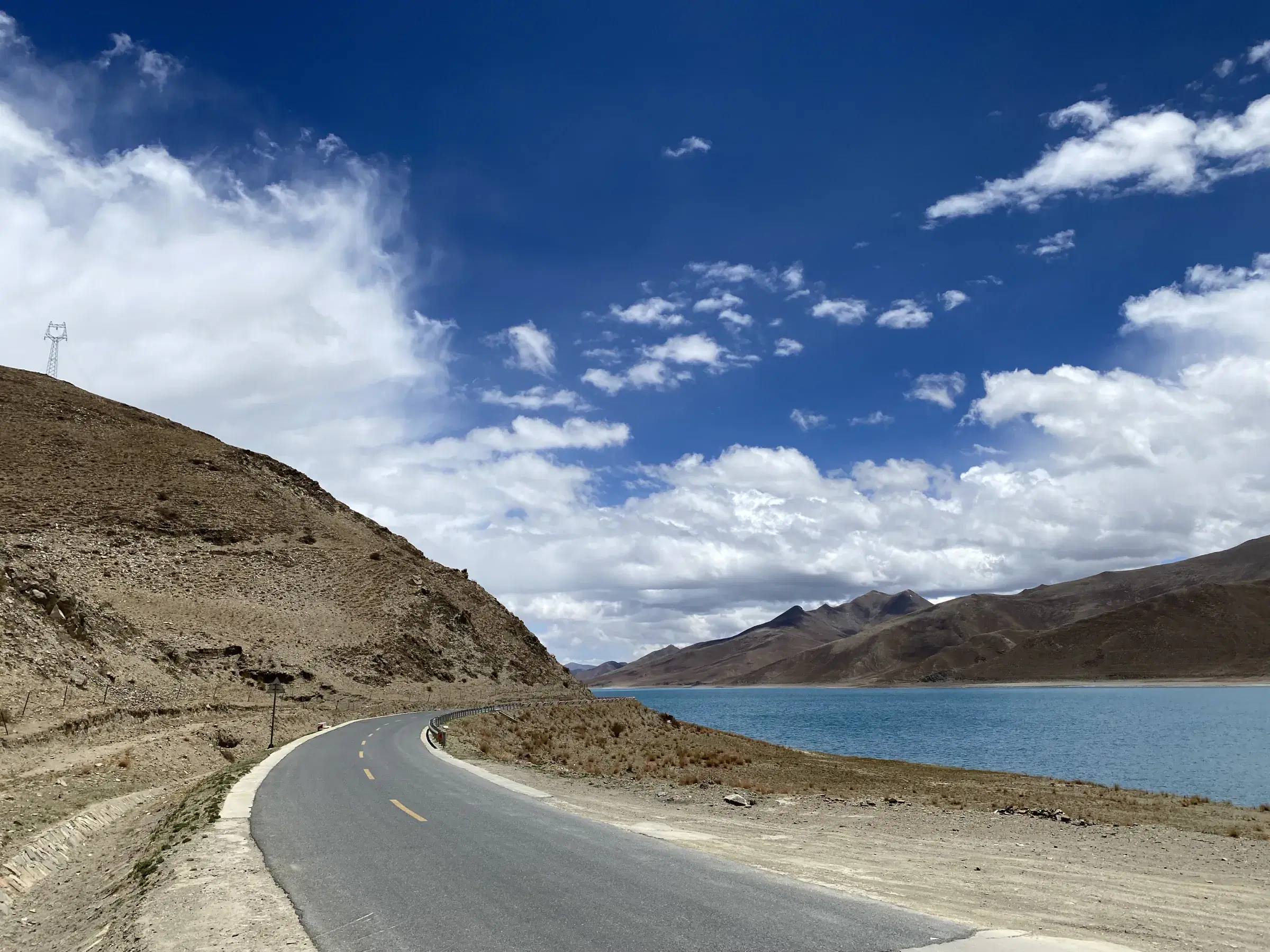 Mountain landscape featuring rocky terrain, water, and cloudy sky.