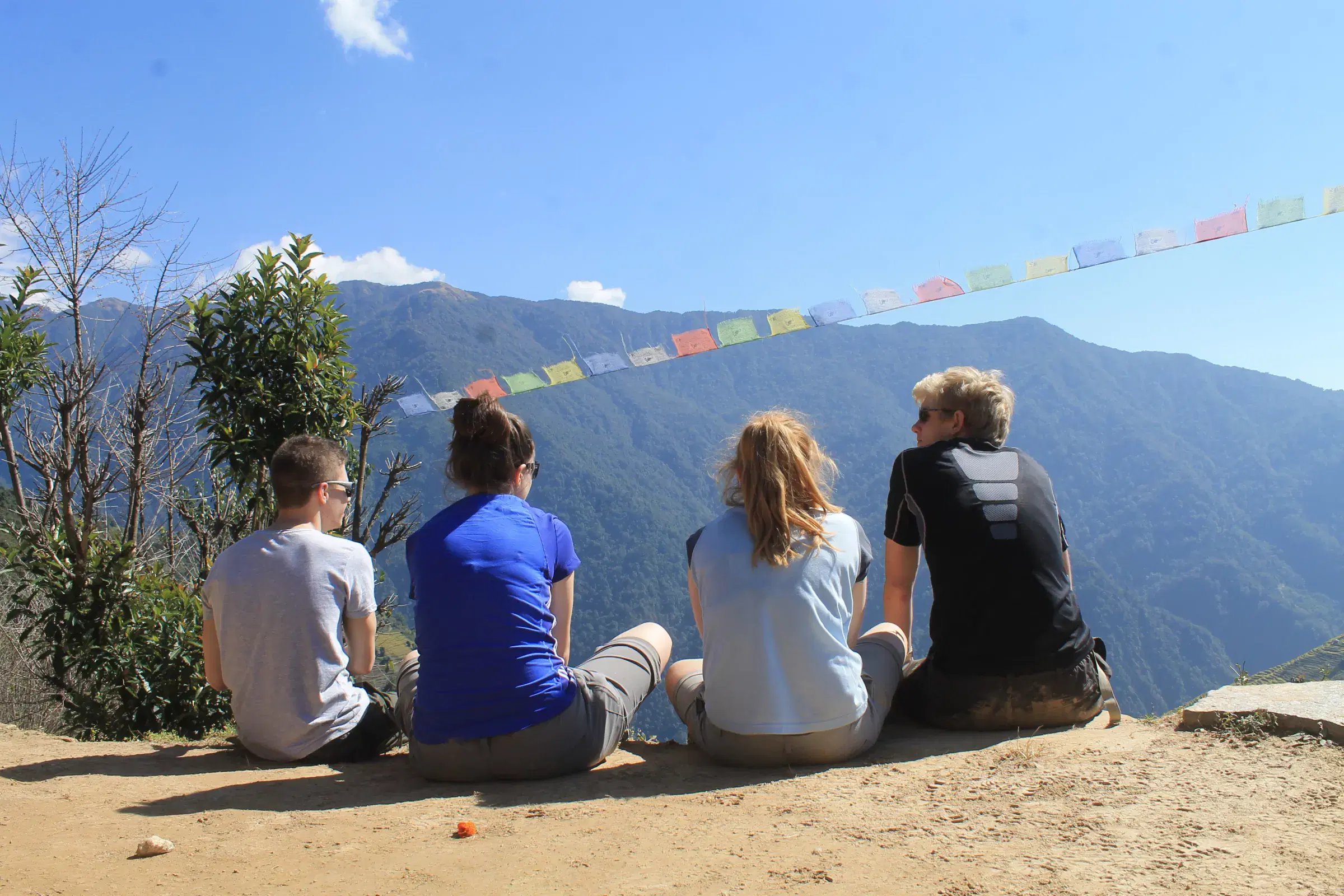 Outdoor scene featuring people, rocky terrain, and cloudy sky.