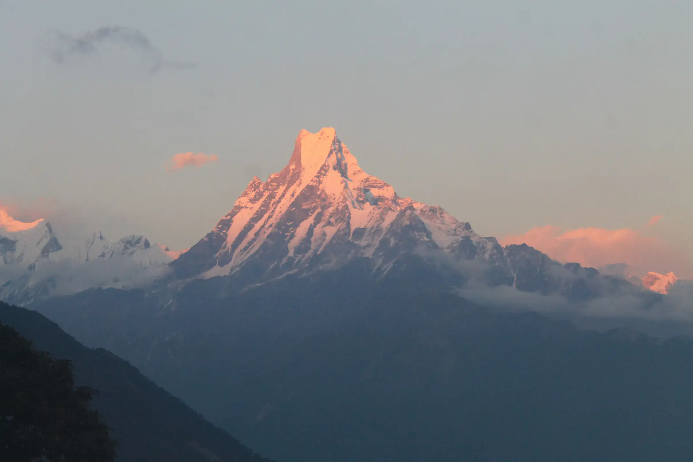 Mountain landscape featuring snowy terrain, water, and cloudy sky.