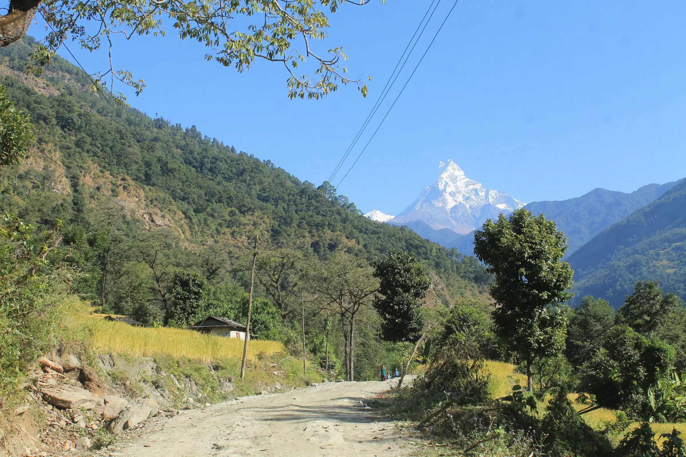 Mountain landscape featuring rocky terrain, blue sky, and greenery.