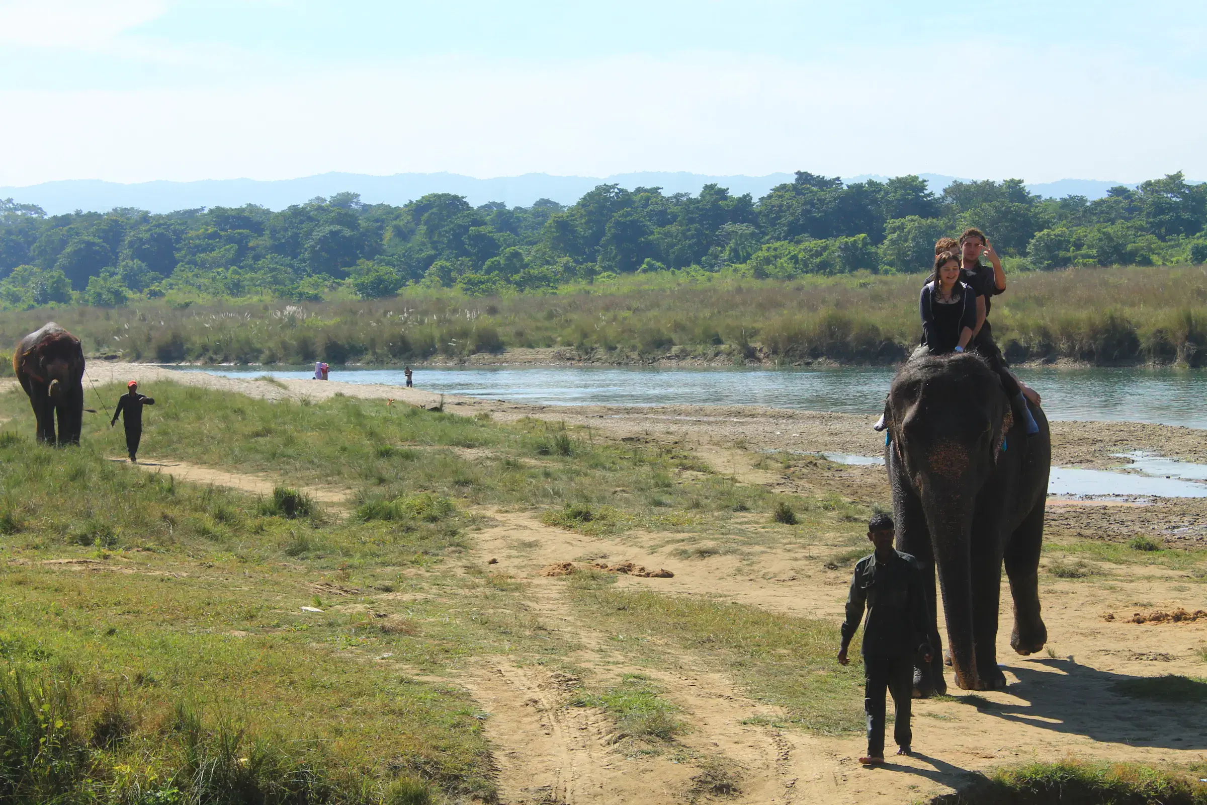 Outdoor scene featuring people, cloudy sky, and greenery.