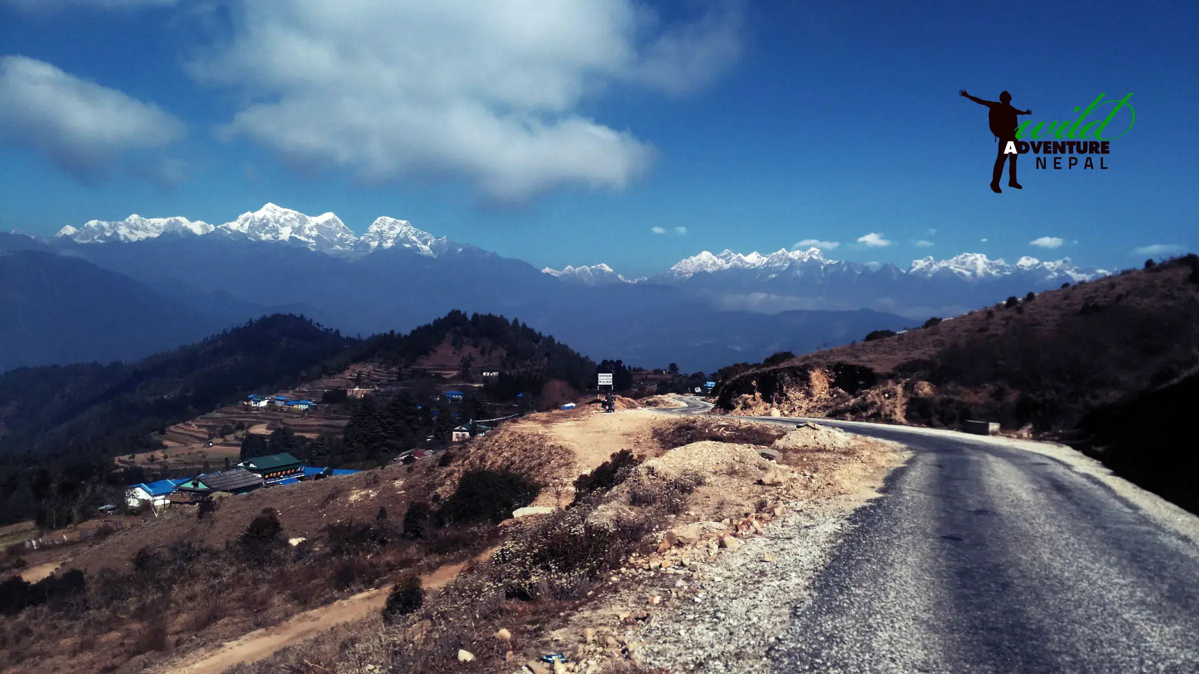 Mountain landscape featuring rocky terrain, a built structure, and cloudy sky.
