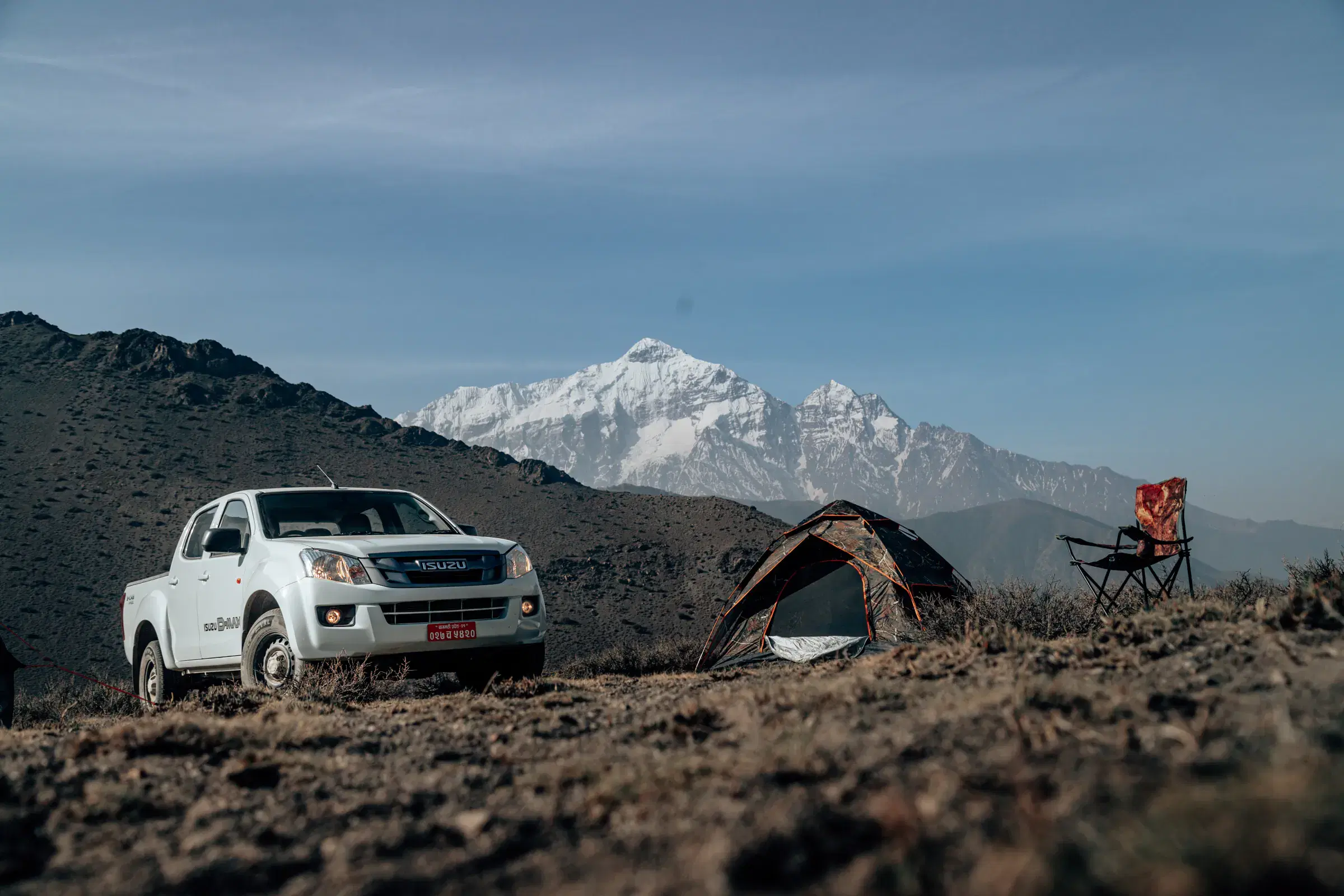 Mountain landscape featuring snowy terrain, water, and cloudy sky.