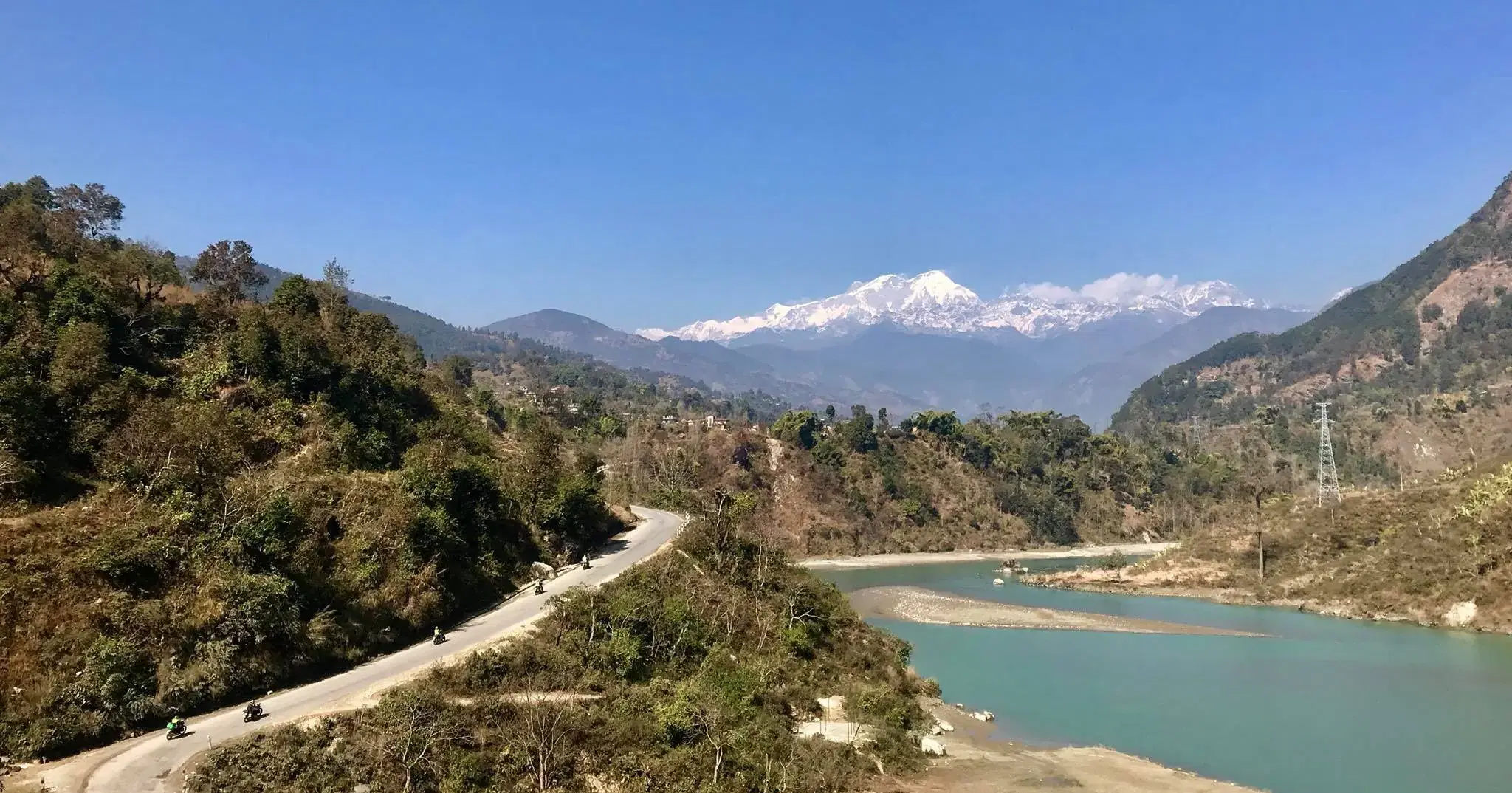 Mountain landscape featuring rocky terrain, water, and blue sky.