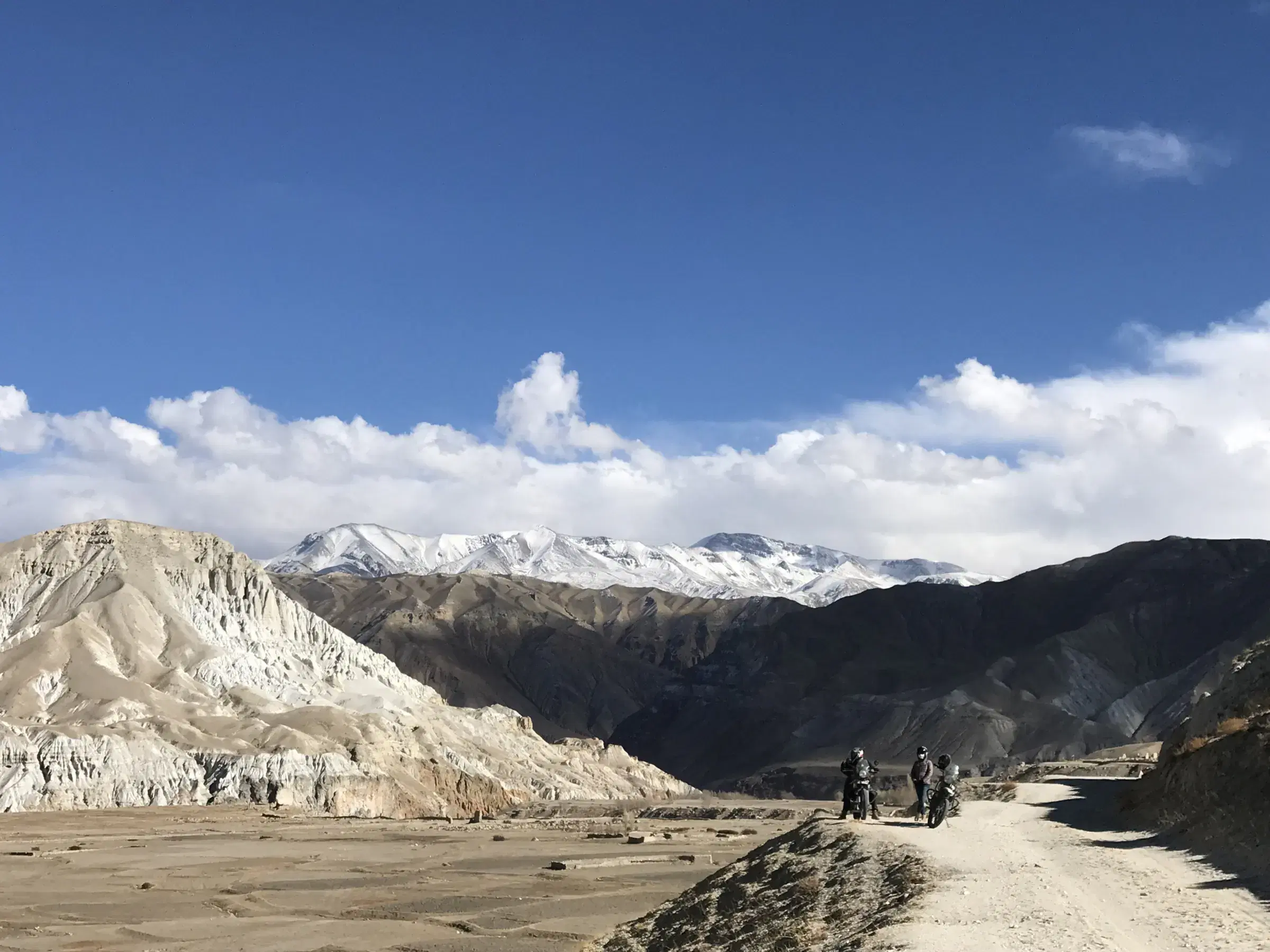 Mountain landscape featuring rocky terrain, a built structure, and cloudy sky.