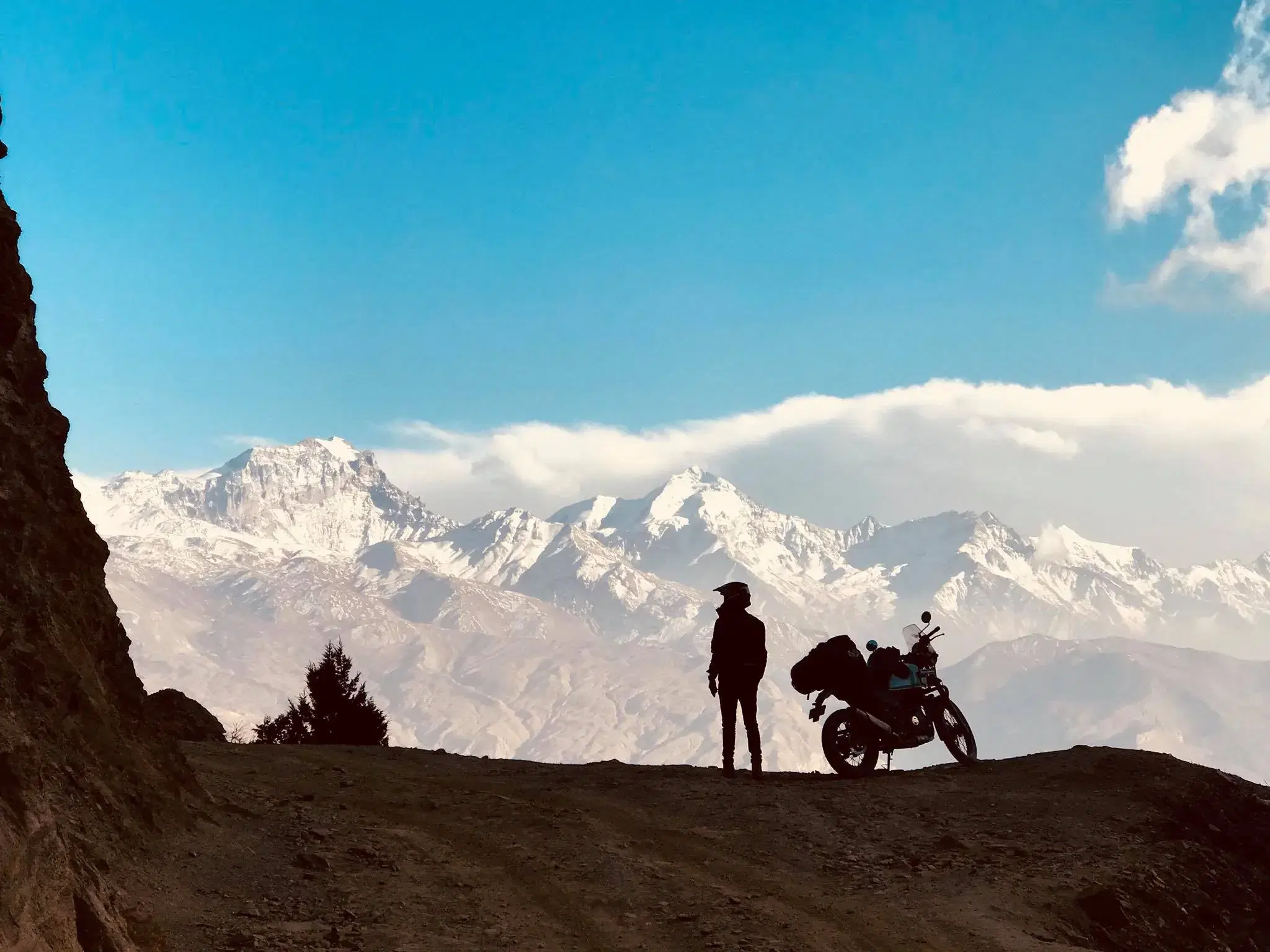 Outdoor scene featuring people, snowy terrain, and cloudy sky.