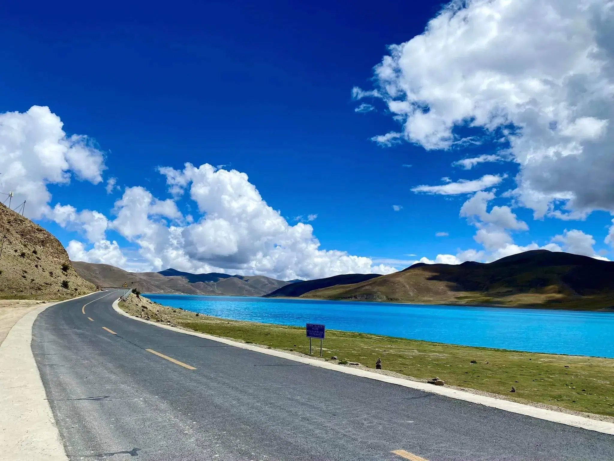 Mountain landscape featuring rocky terrain, cloudy sky, and greenery.