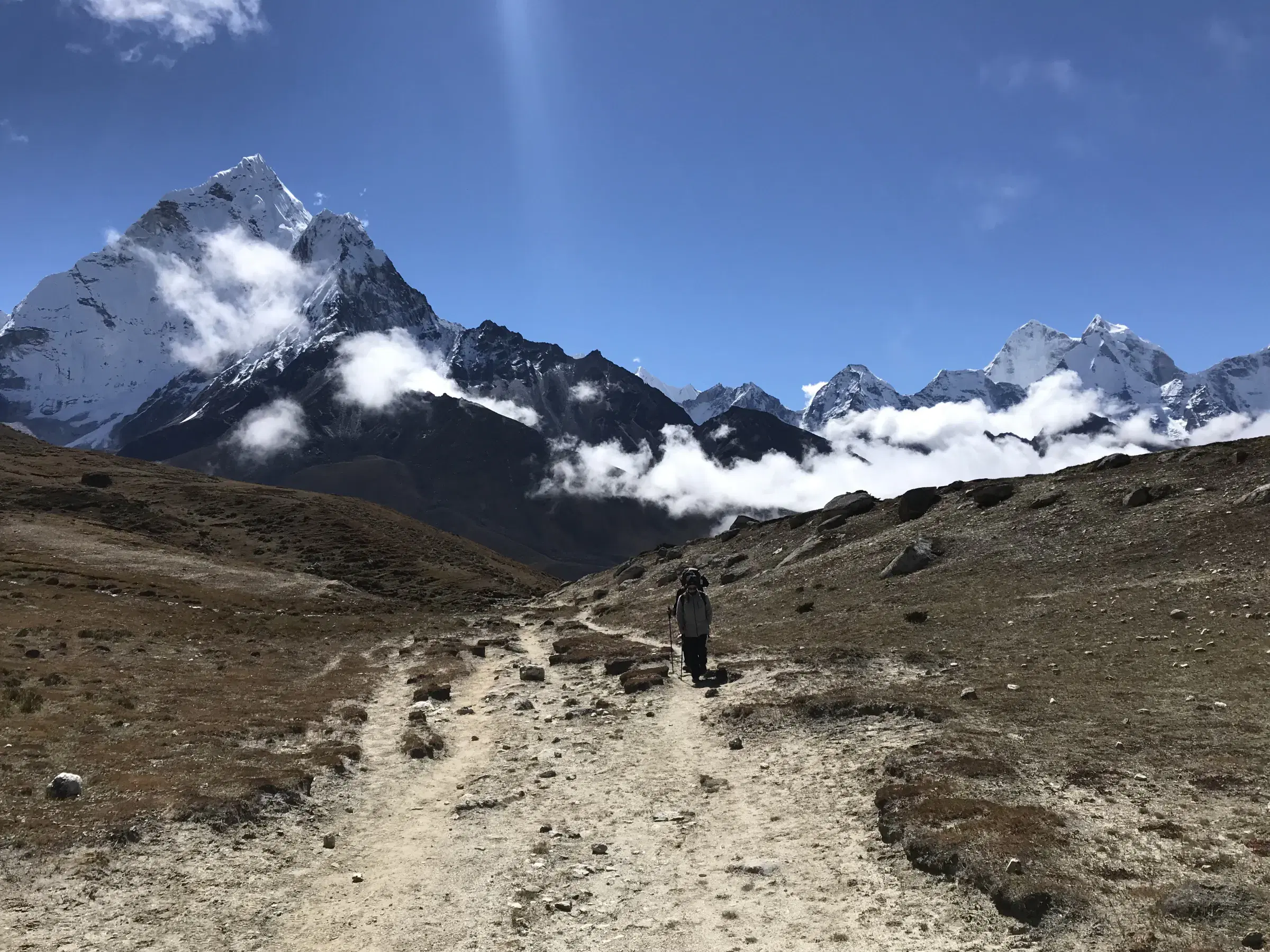 Mountain landscape featuring snowy terrain, water, and blue sky.