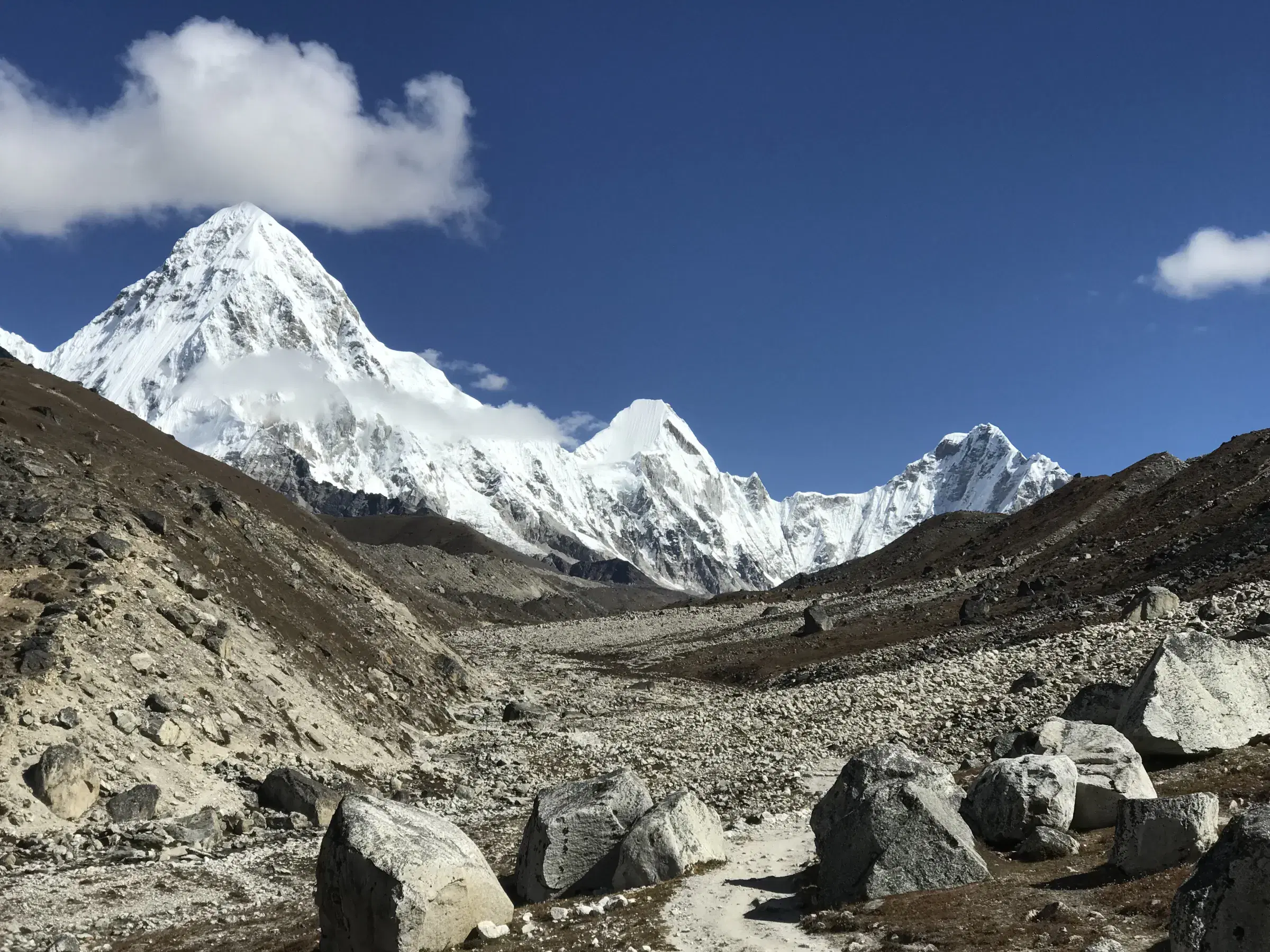 Mountain landscape featuring snowy terrain, a built structure, and cloudy sky.
