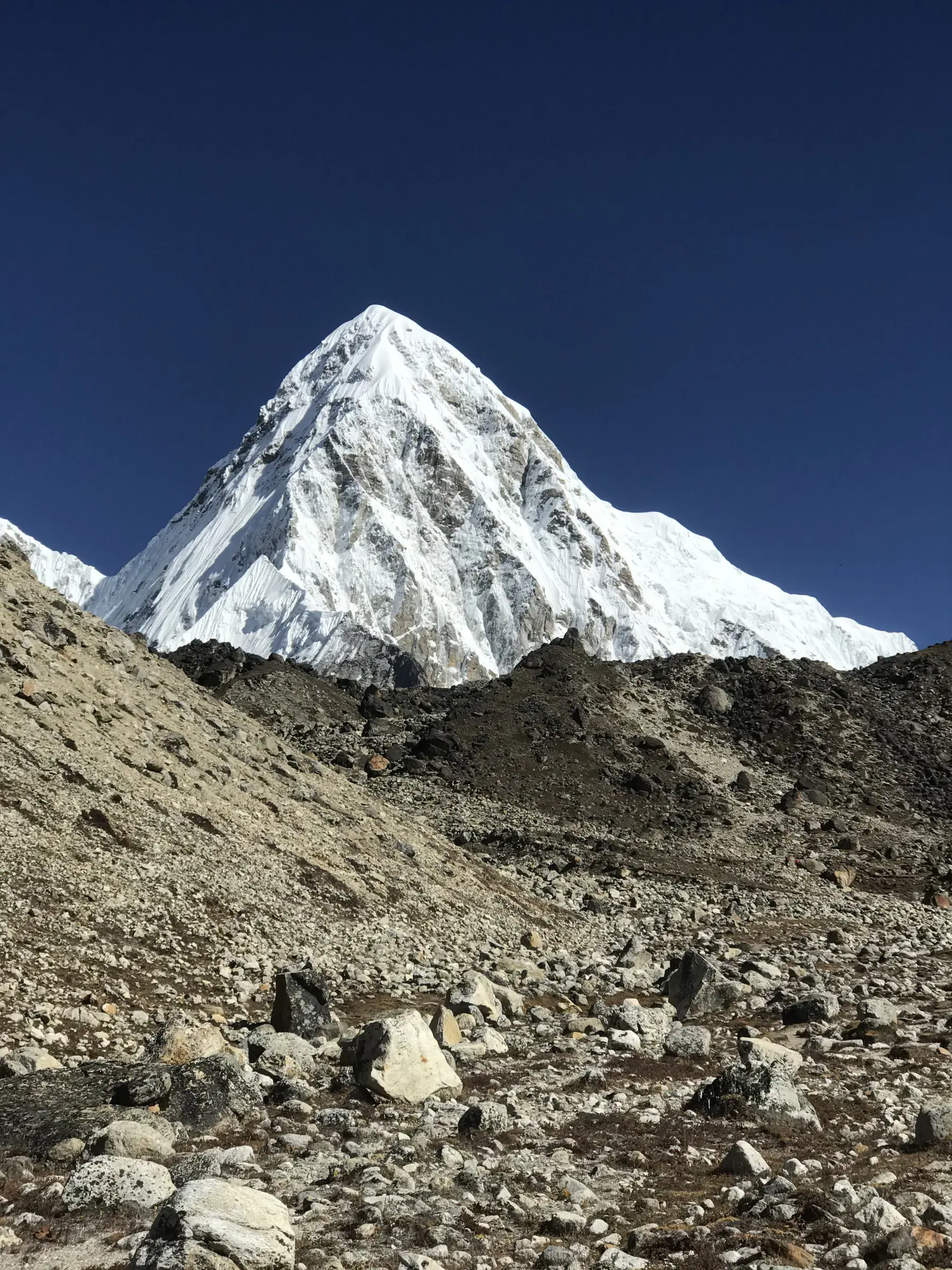 Mountain landscape featuring snowy terrain, water, and blue sky.