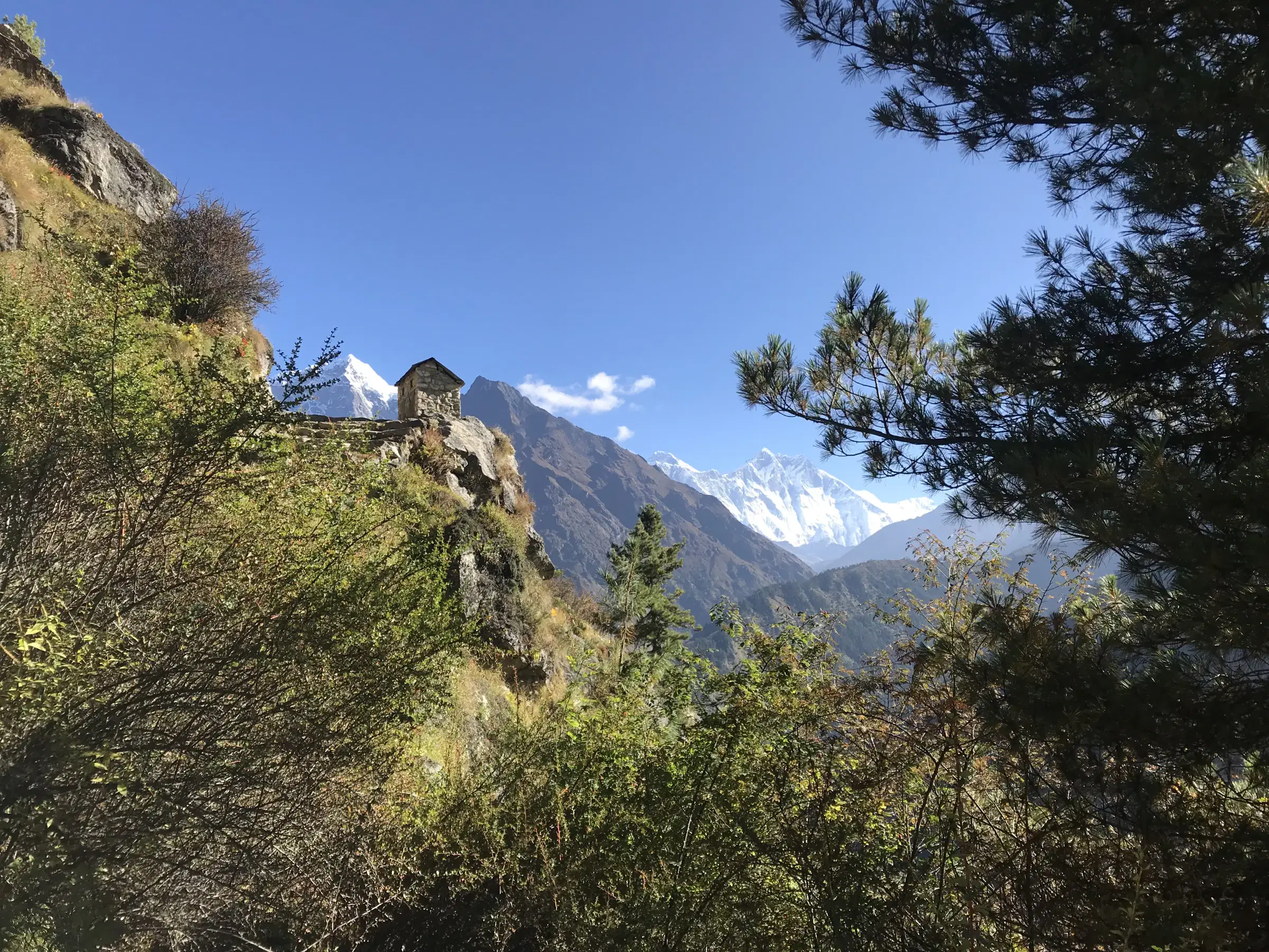 Mountain landscape featuring snowy terrain, a built structure, and blue sky.