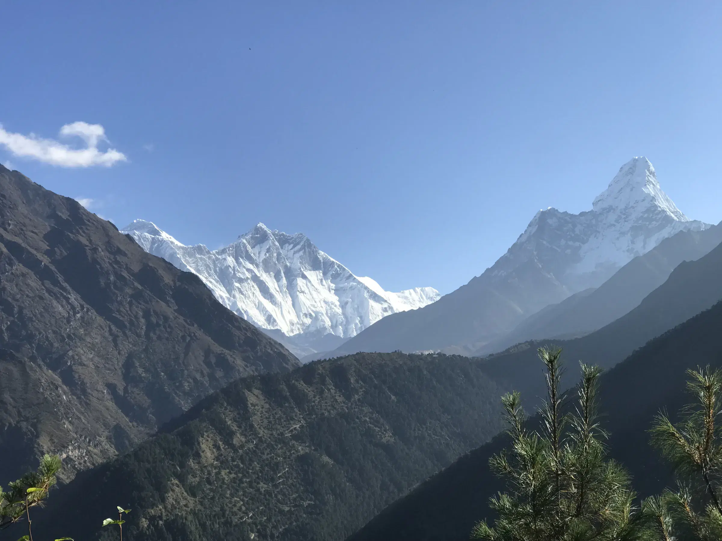 Mountain landscape featuring snowy terrain, water, and cloudy sky.