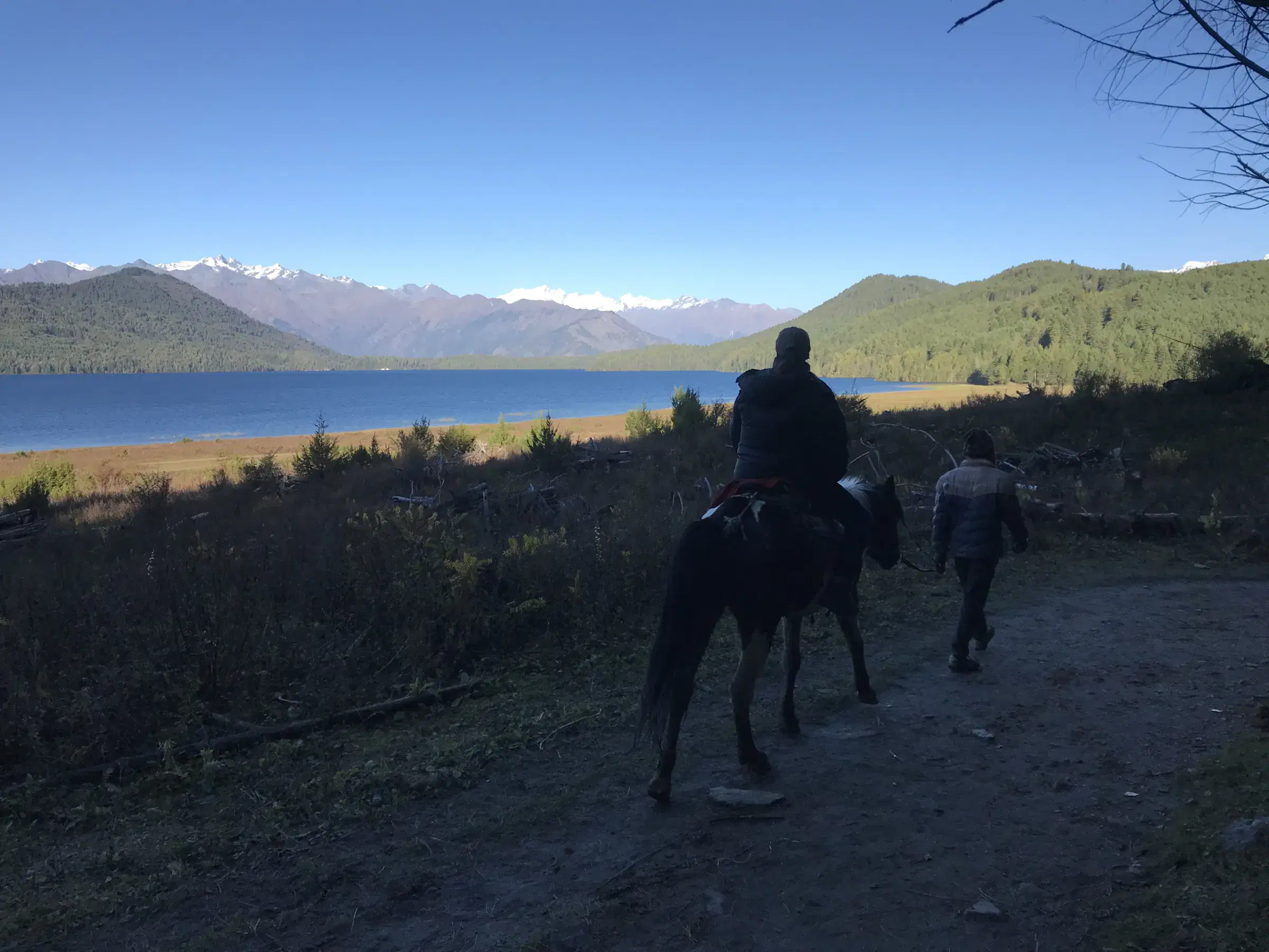 Outdoor scene featuring people, rocky terrain, and blue sky.