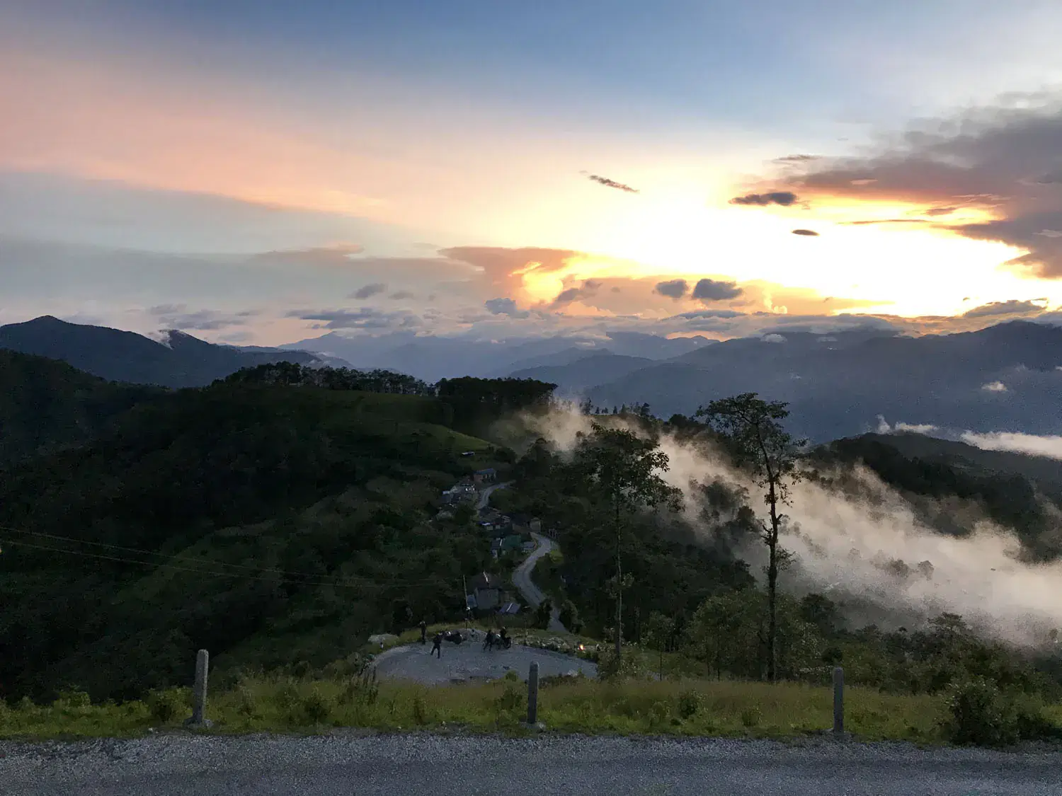 Mountain landscape featuring rocky terrain, cloudy sky, and greenery.