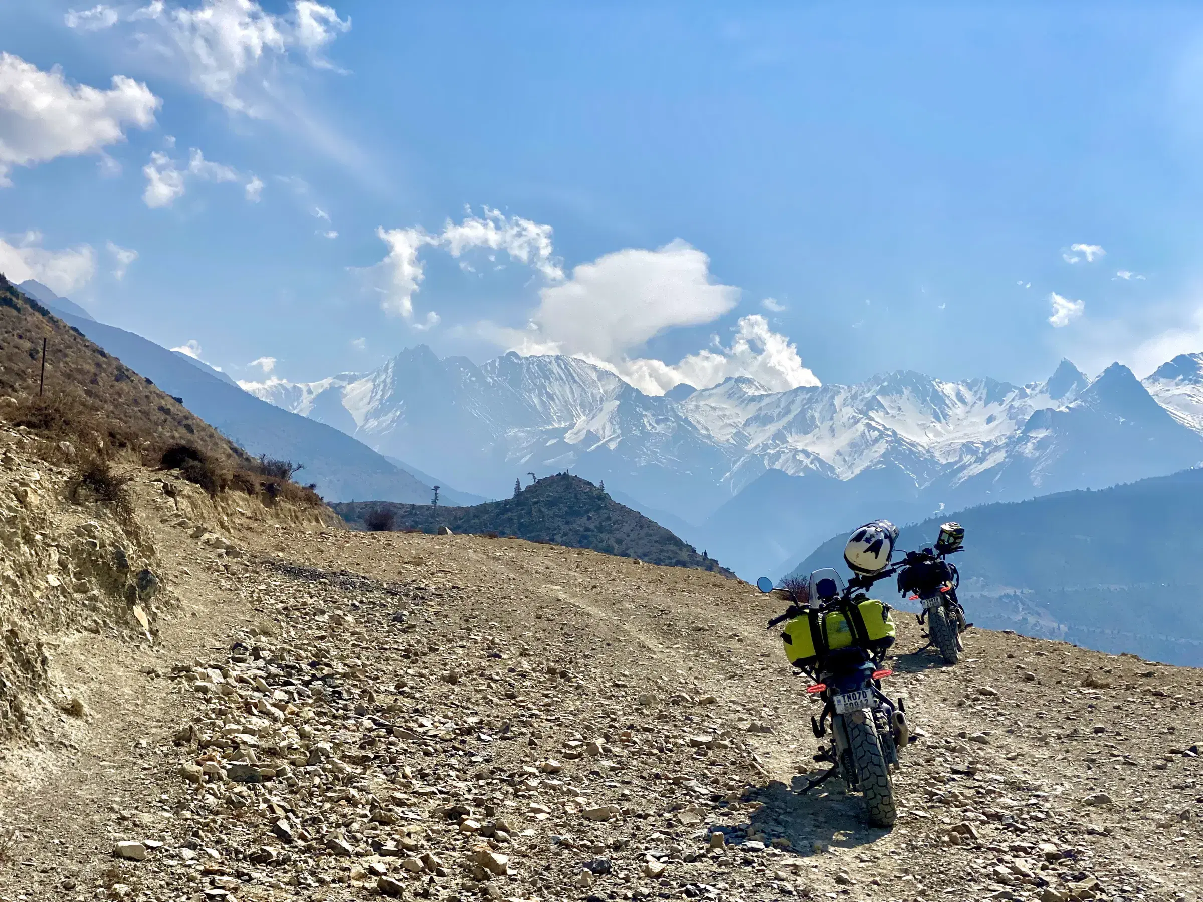 Outdoor scene featuring people, rocky terrain, and cloudy sky.