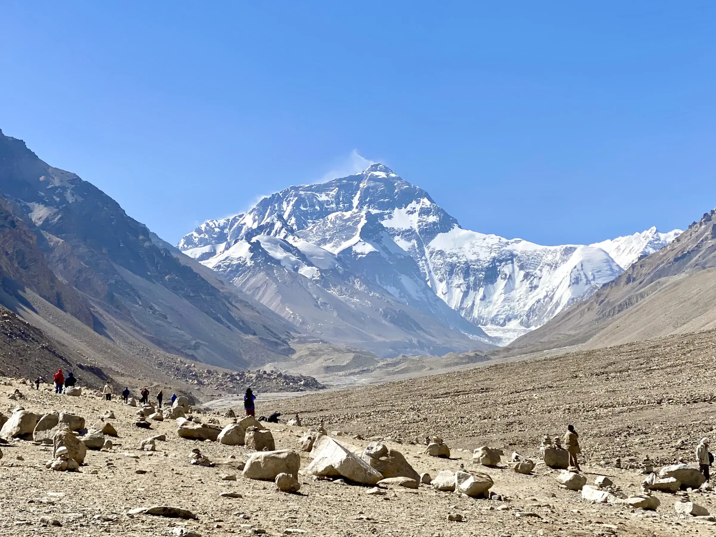 Mountain landscape featuring snowy terrain, water, and blue sky.