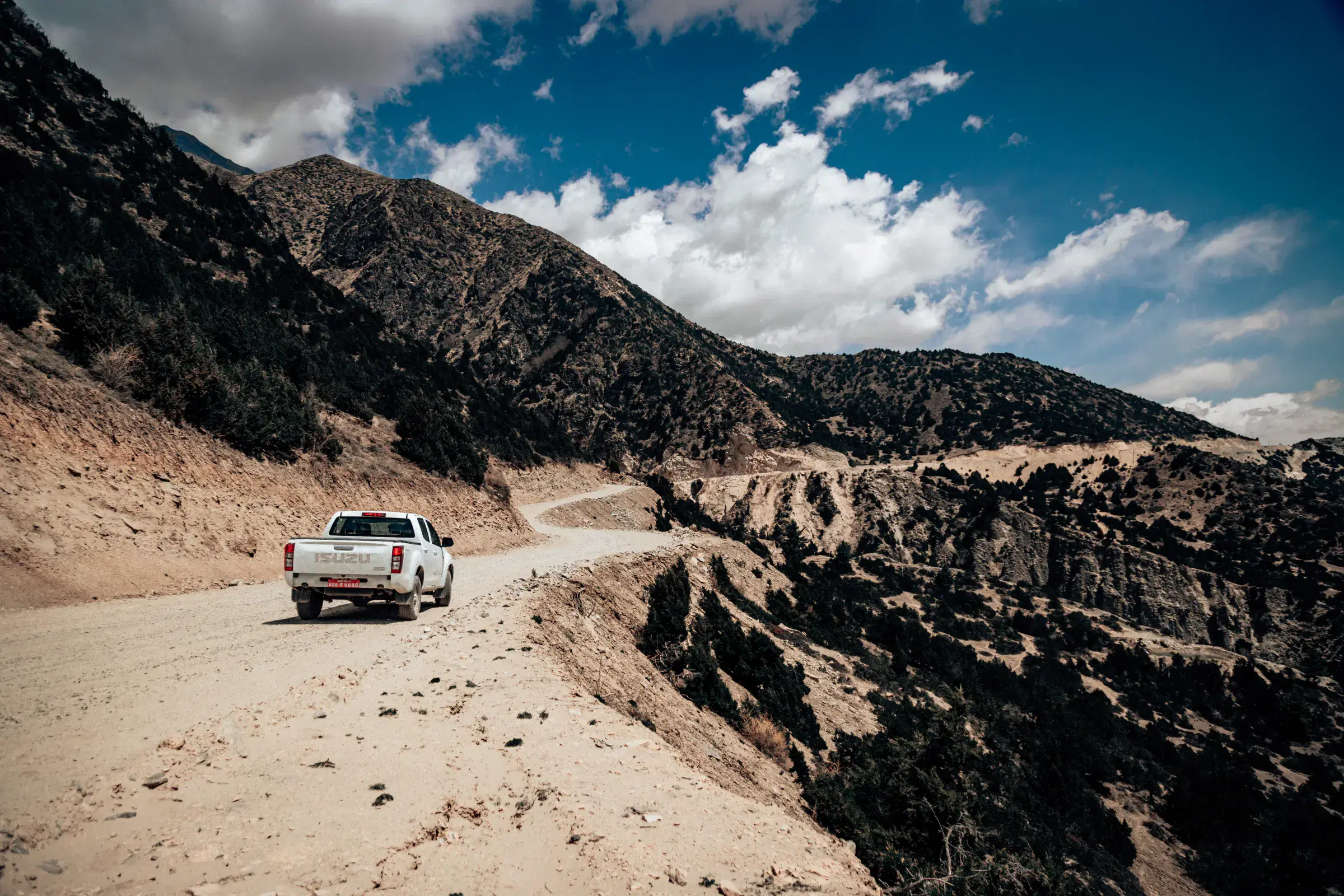 Mountain landscape featuring rocky terrain, a built structure, and cloudy sky.