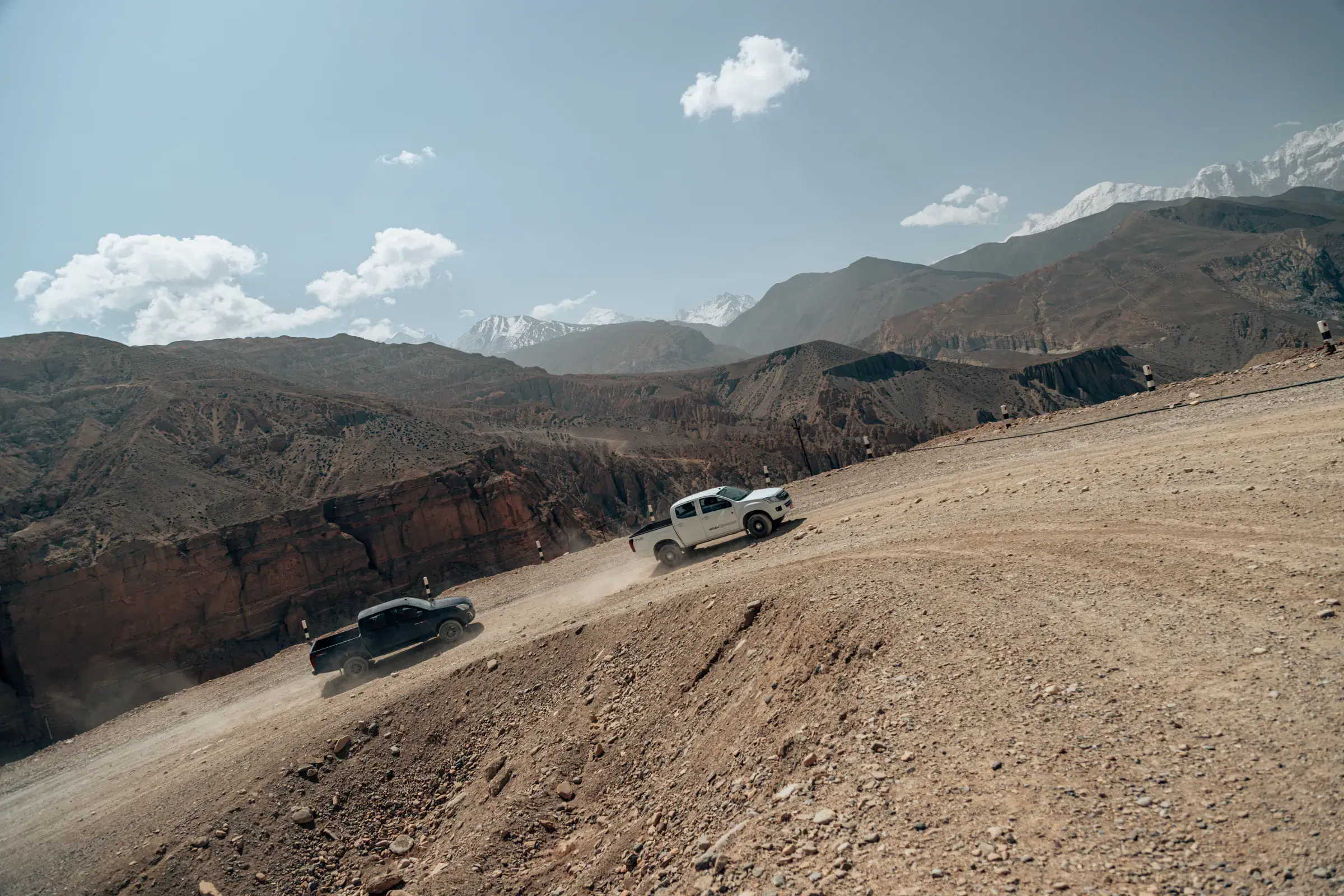 Mountain landscape featuring rocky terrain, a built structure, and cloudy sky.