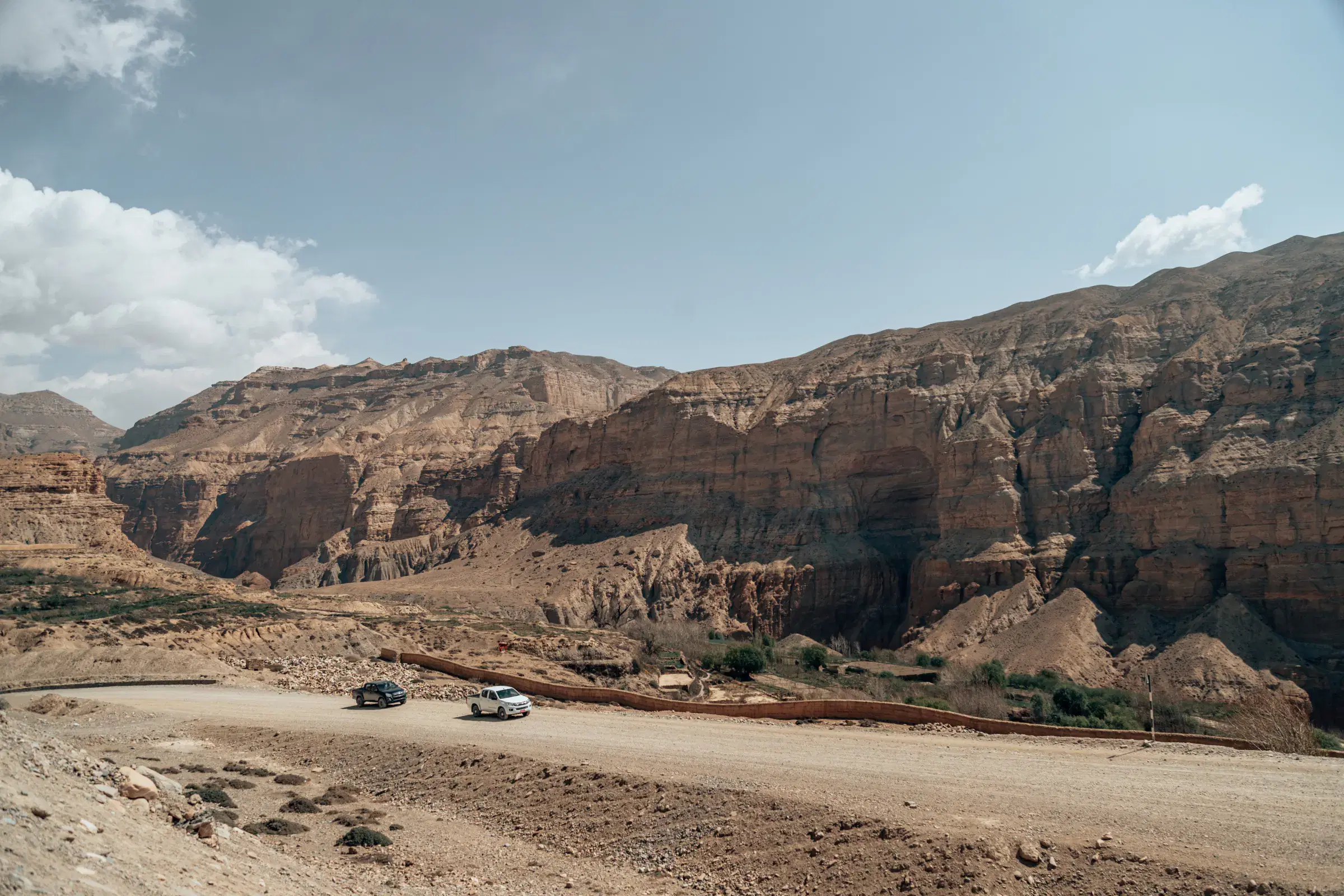 Mountain landscape featuring rocky terrain, a built structure, and cloudy sky.