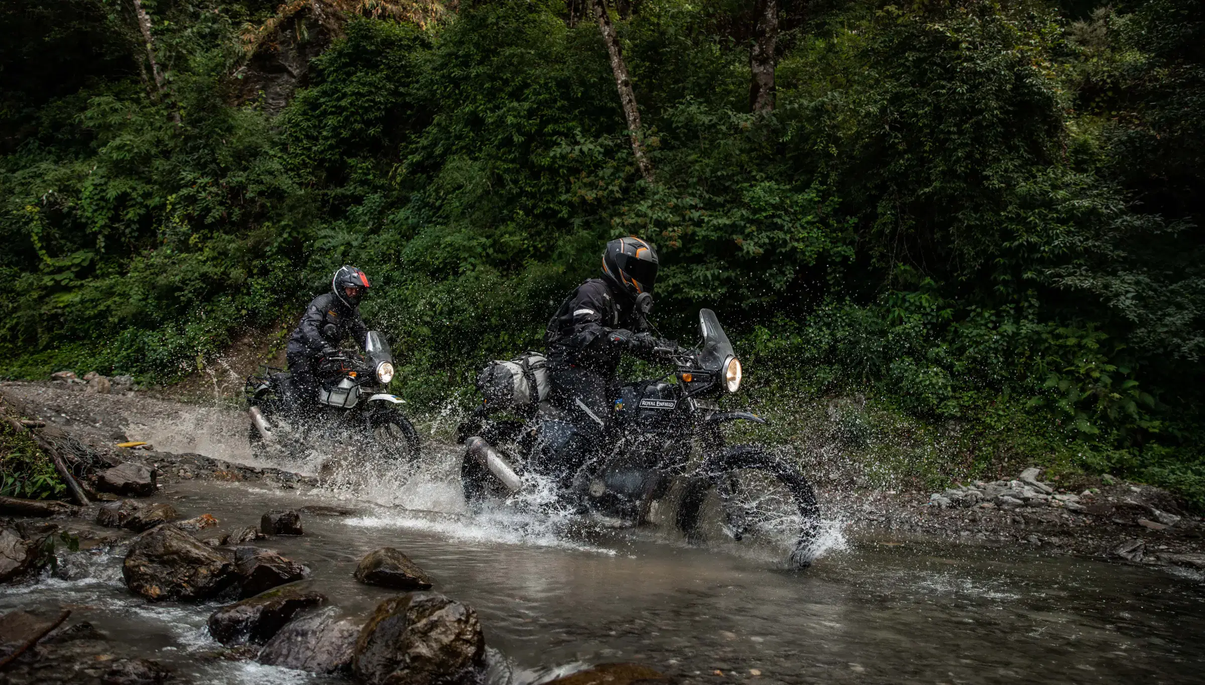 Outdoor scene featuring people, rocky terrain, and a built structure.