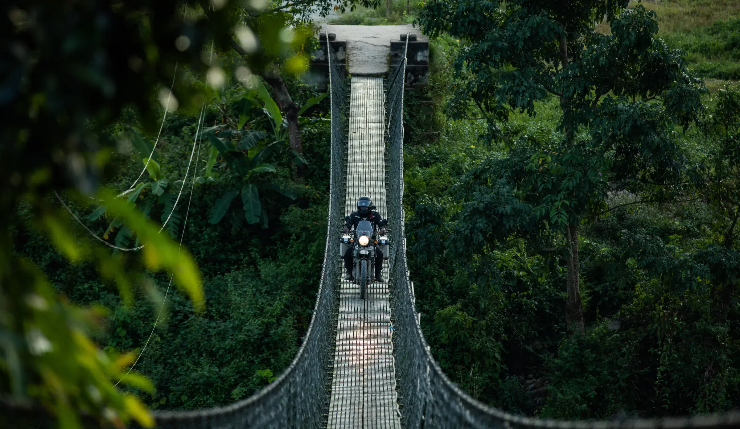Outdoor scene featuring people, a built structure, and greenery.