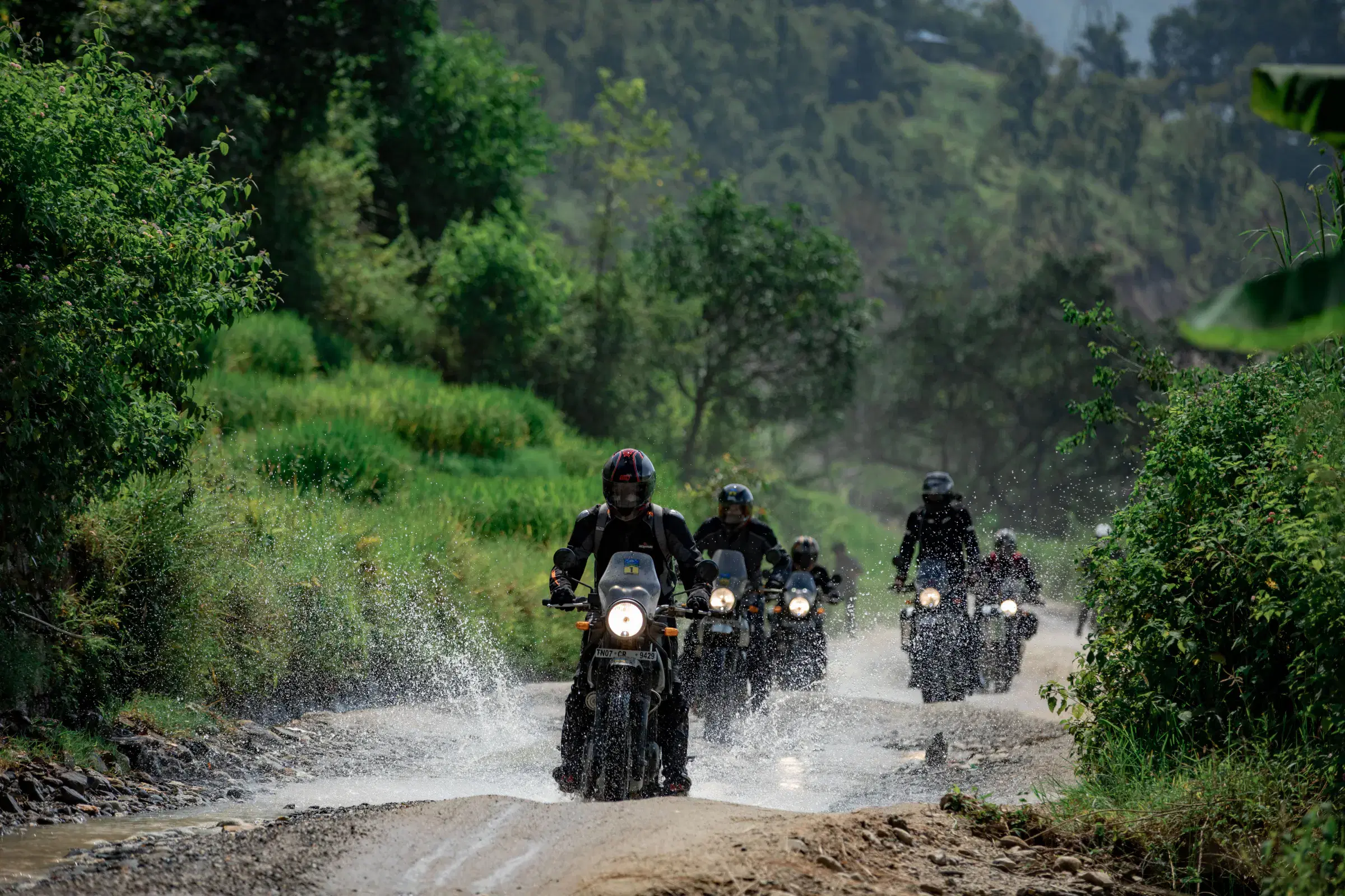 Outdoor adventure scene featuring people, a vehicle, and greenery.