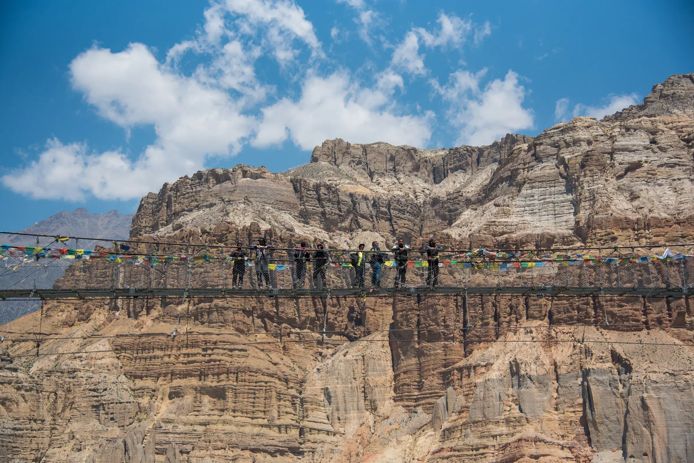 Mountain landscape featuring rocky terrain, a built structure, and cloudy sky.