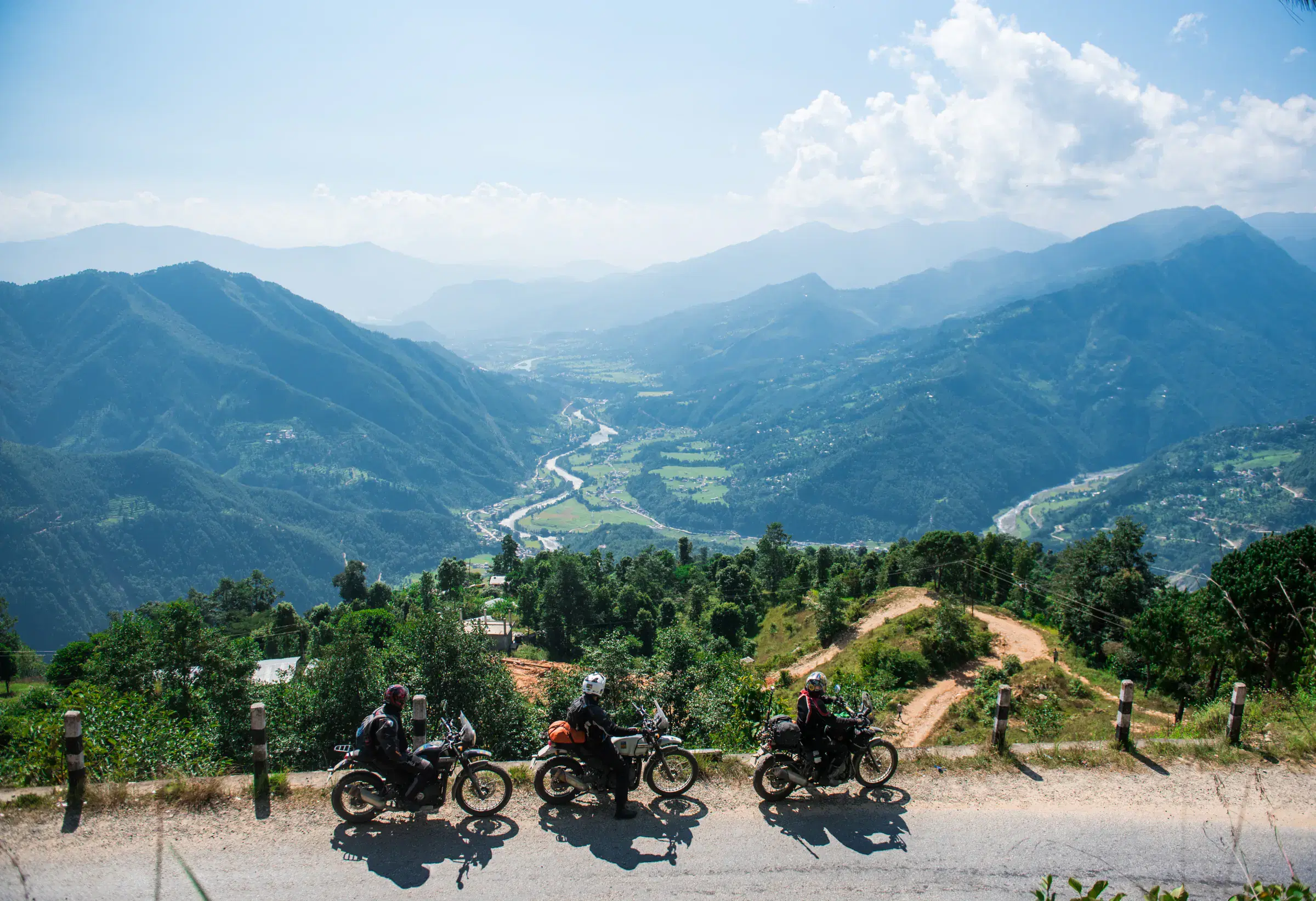 Mountain landscape featuring rocky terrain, cloudy sky, and greenery.