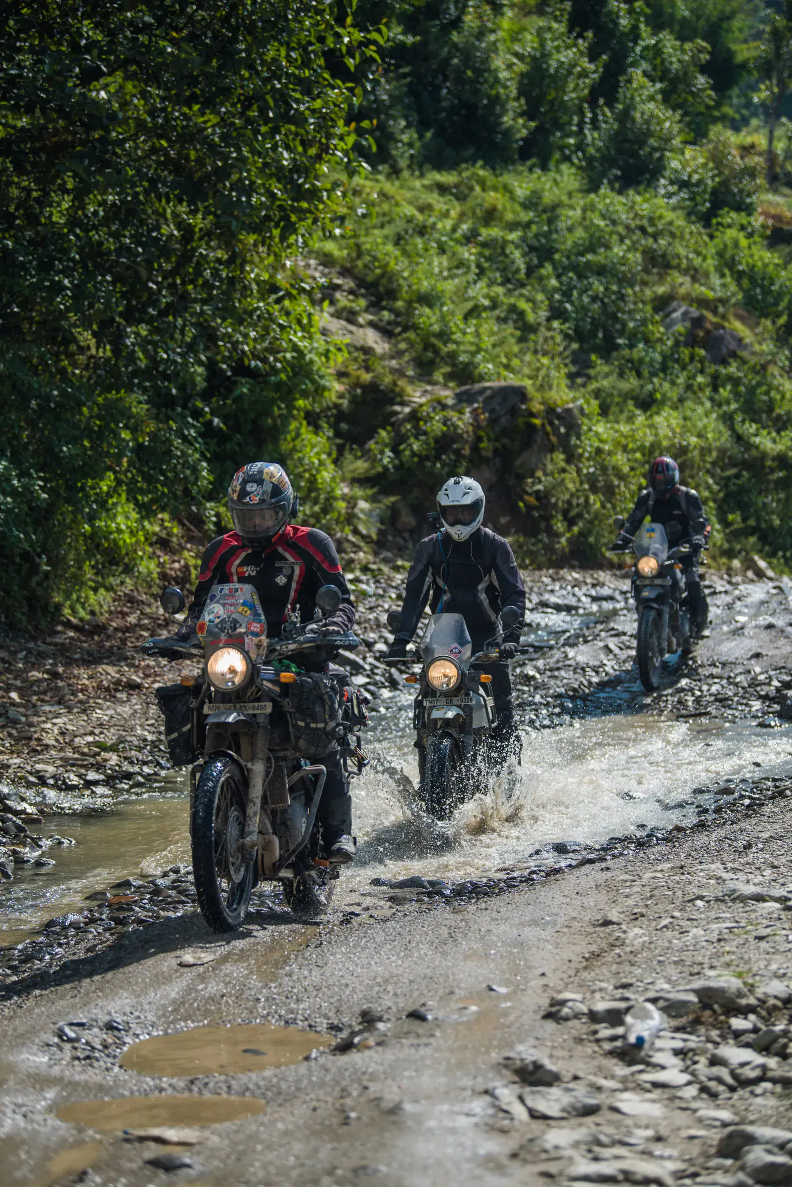 Portrait-oriented Outdoor adventure scene featuring people and a vehicle.