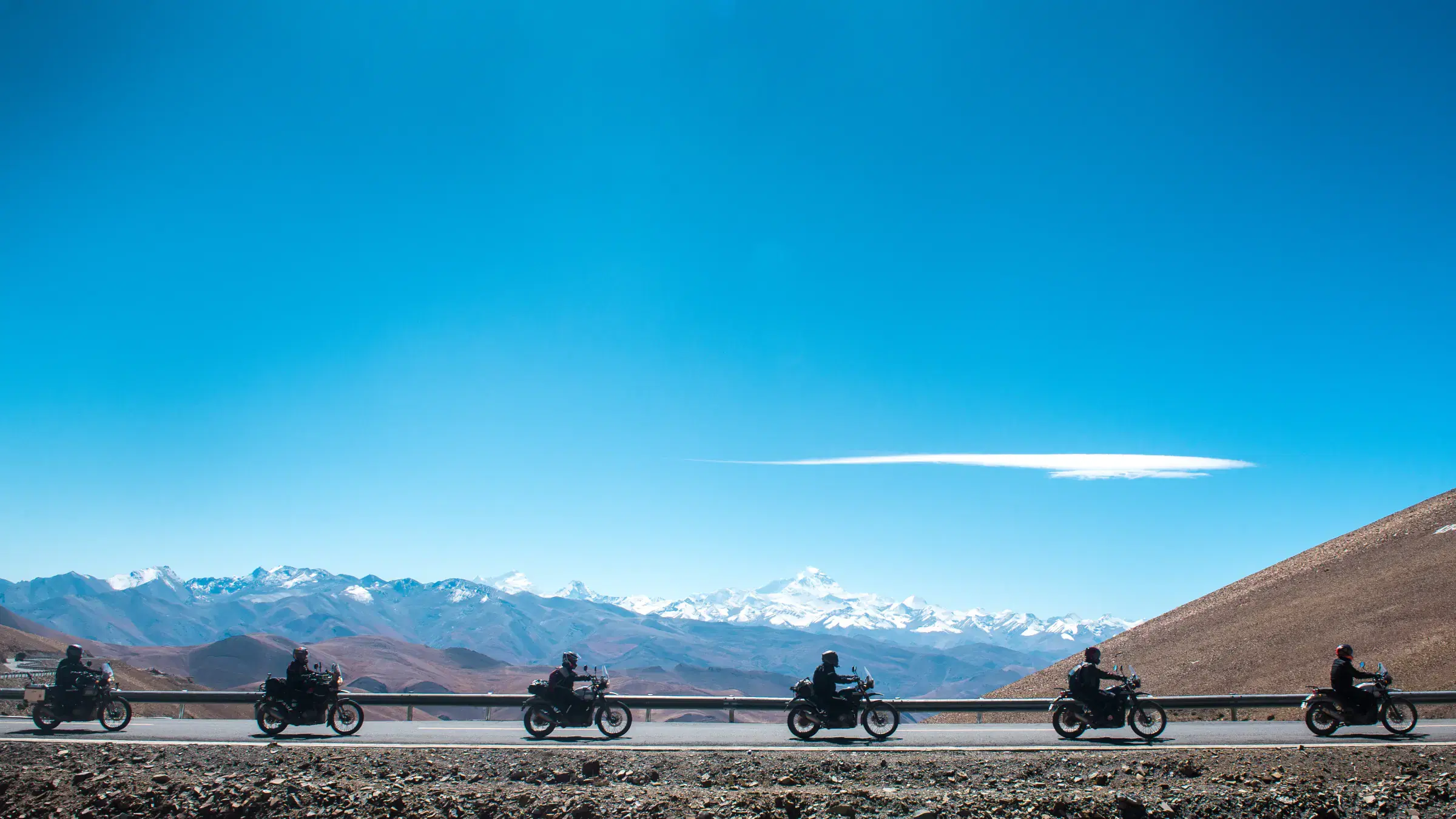 Outdoor vehicle scene featuring a vehicle, rocky terrain, and cloudy sky.