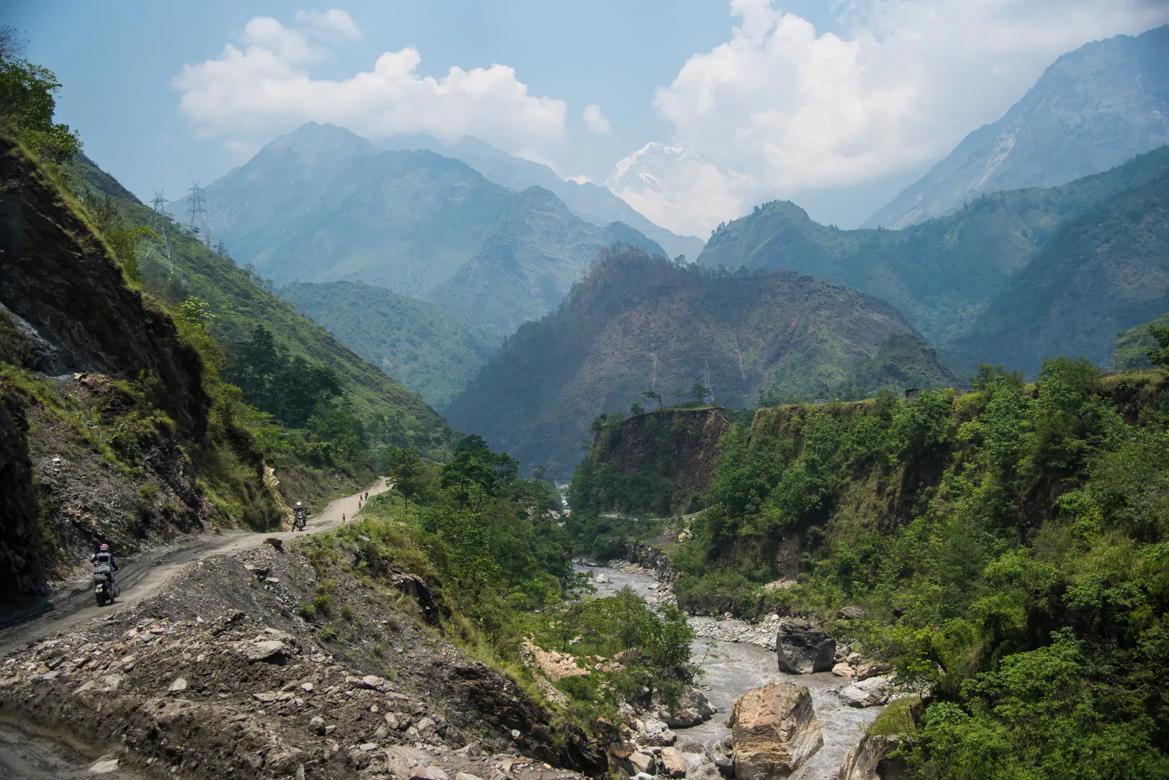 Mountain landscape featuring rocky terrain, a built structure, and cloudy sky.