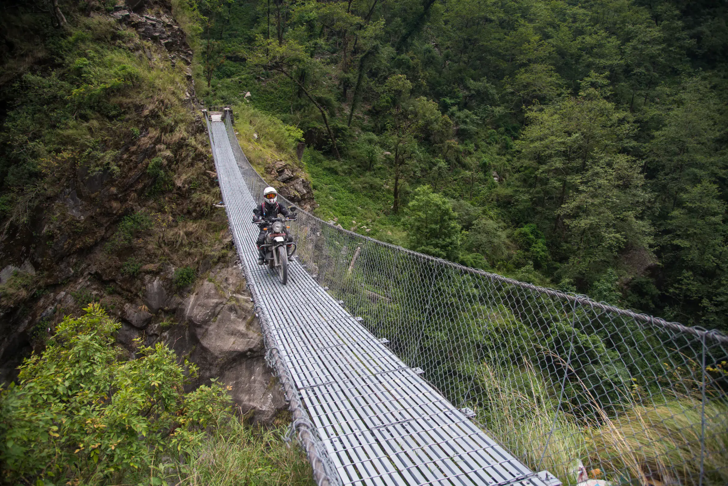 Mountain landscape featuring rocky terrain, a built structure, and greenery.