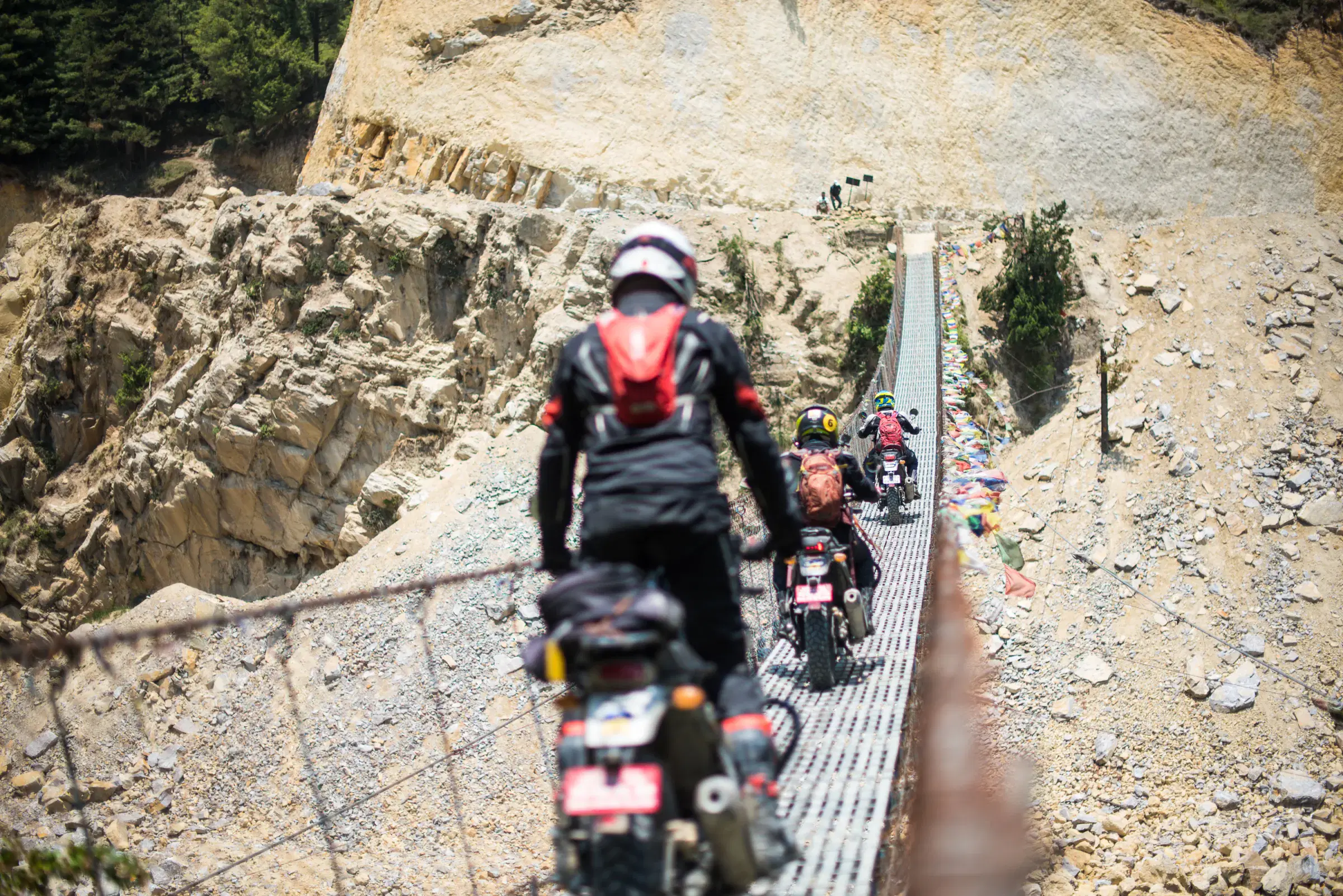 Outdoor scene featuring people, rocky terrain, and a built structure.