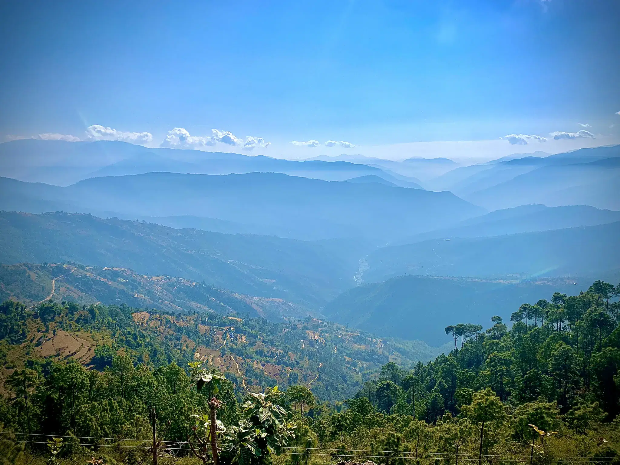Mountain landscape featuring rocky terrain, cloudy sky, and greenery.