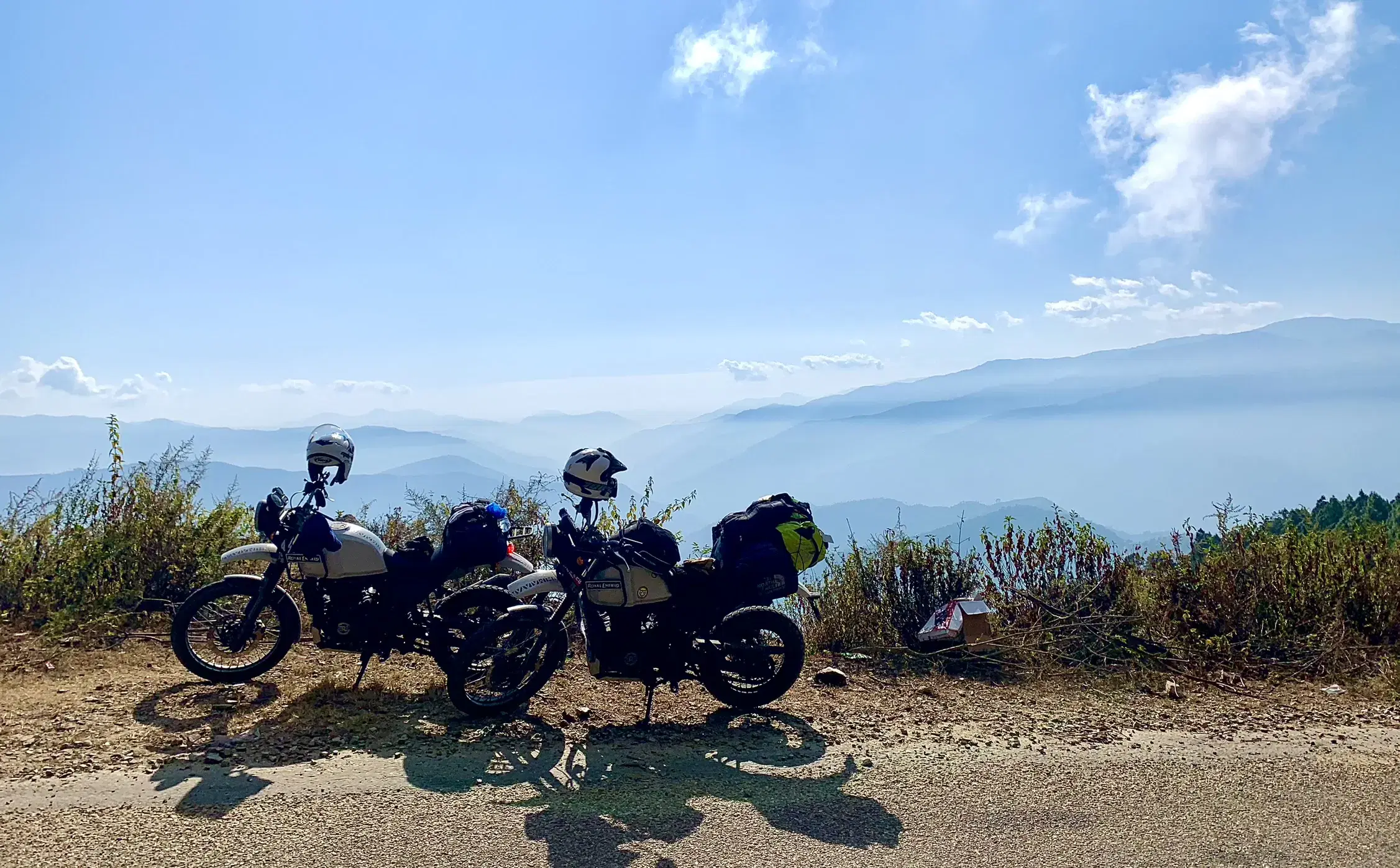Outdoor adventure scene featuring people, a vehicle, rocky terrain, and cloudy sky.