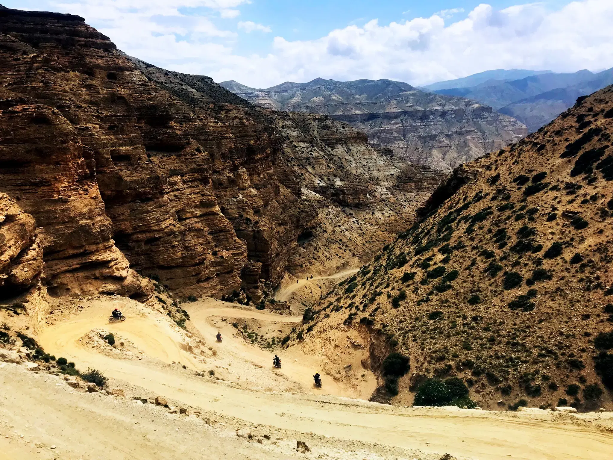 Mountain landscape featuring rocky terrain, a built structure, and cloudy sky.