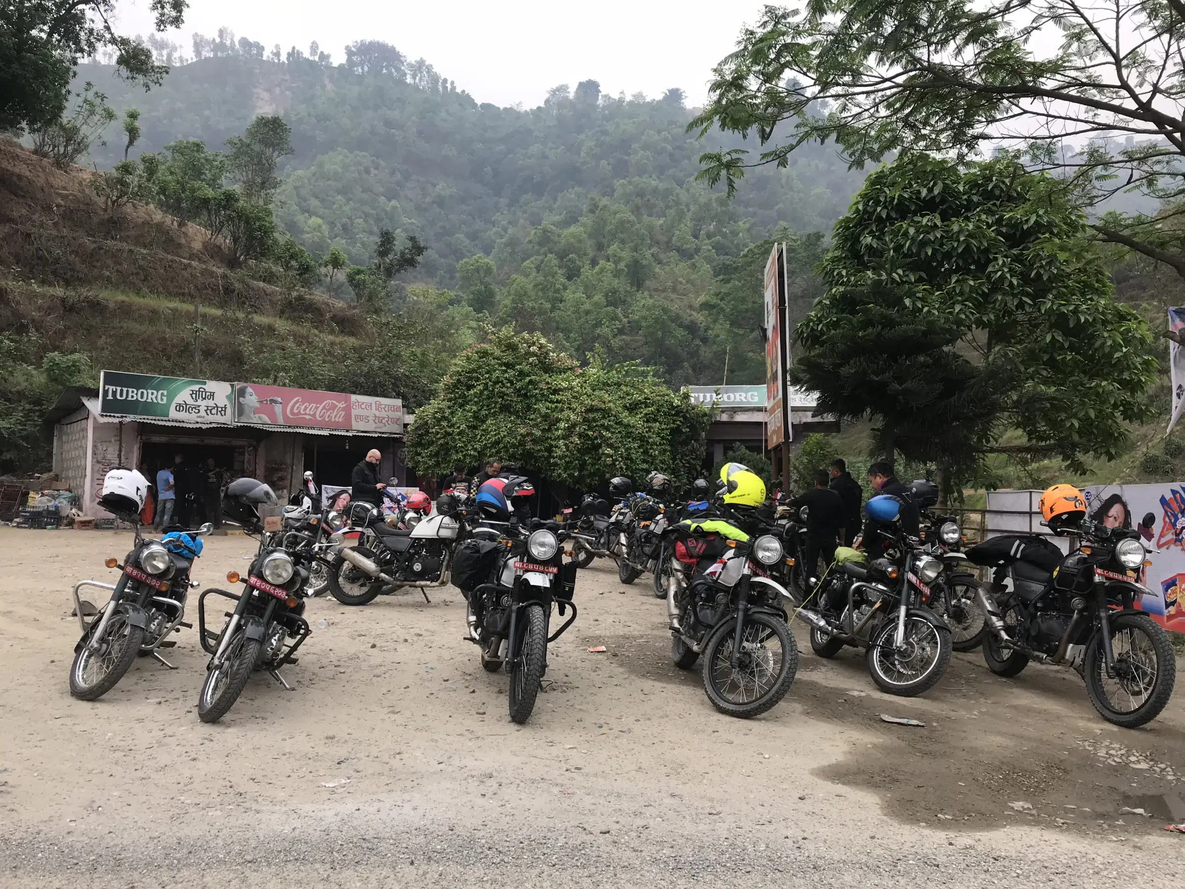 Outdoor adventure scene featuring people, a vehicle, rocky terrain, and greenery.