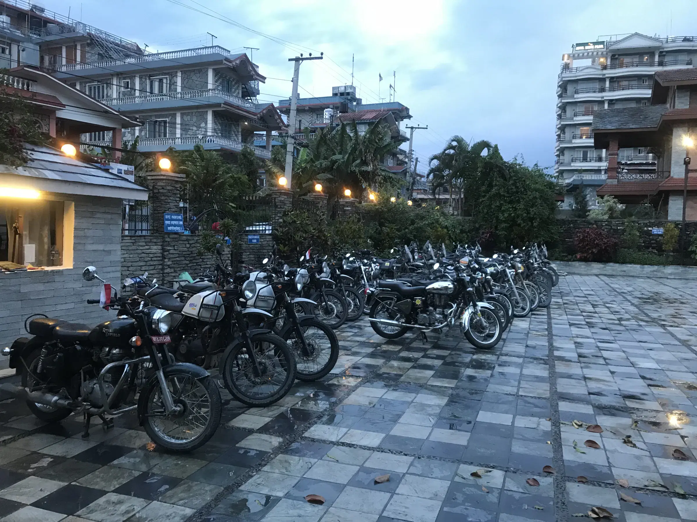 Outdoor vehicle scene featuring a vehicle, cloudy sky, and greenery.