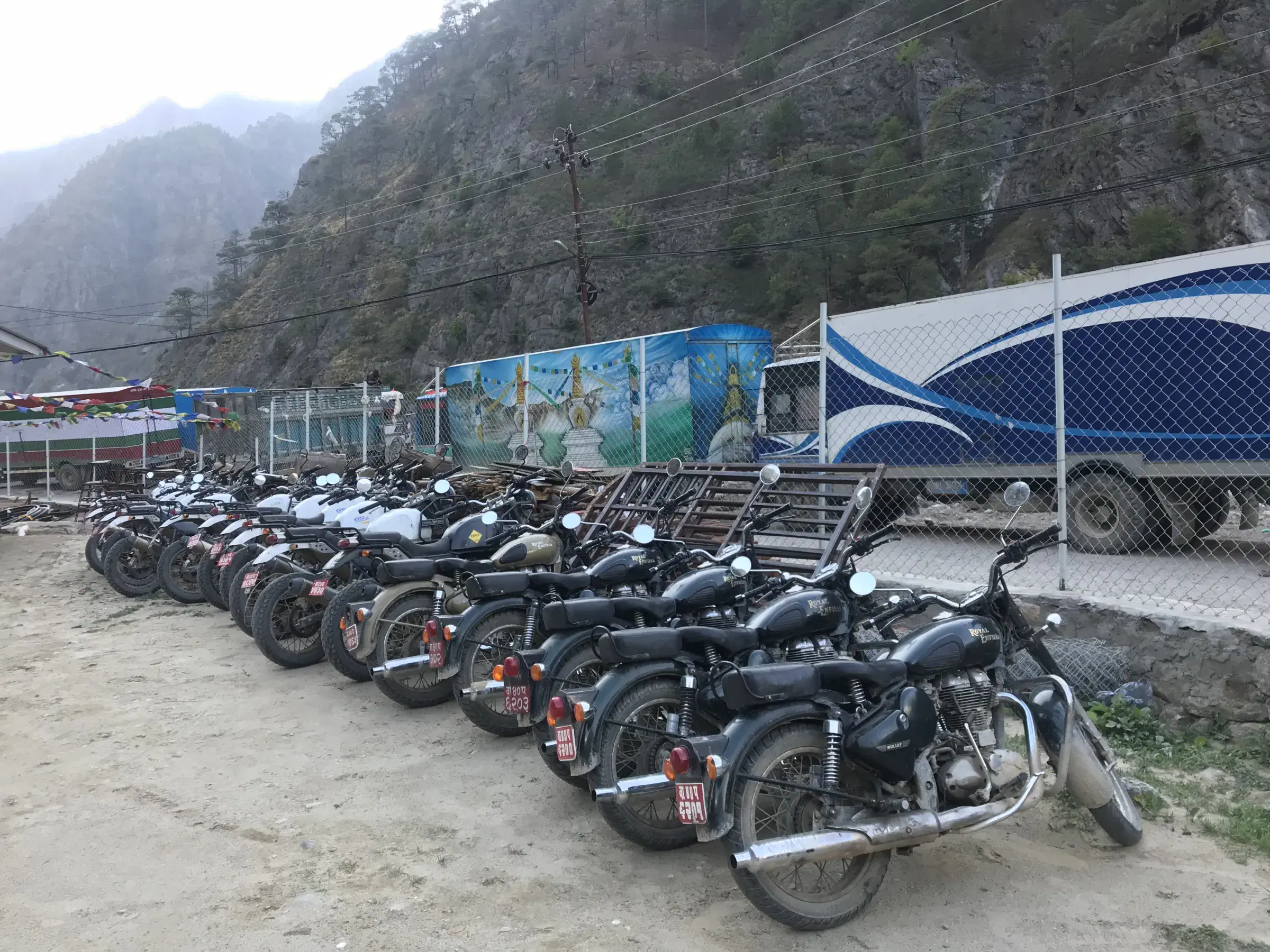 Outdoor vehicle scene featuring a vehicle, rocky terrain, and a built structure.