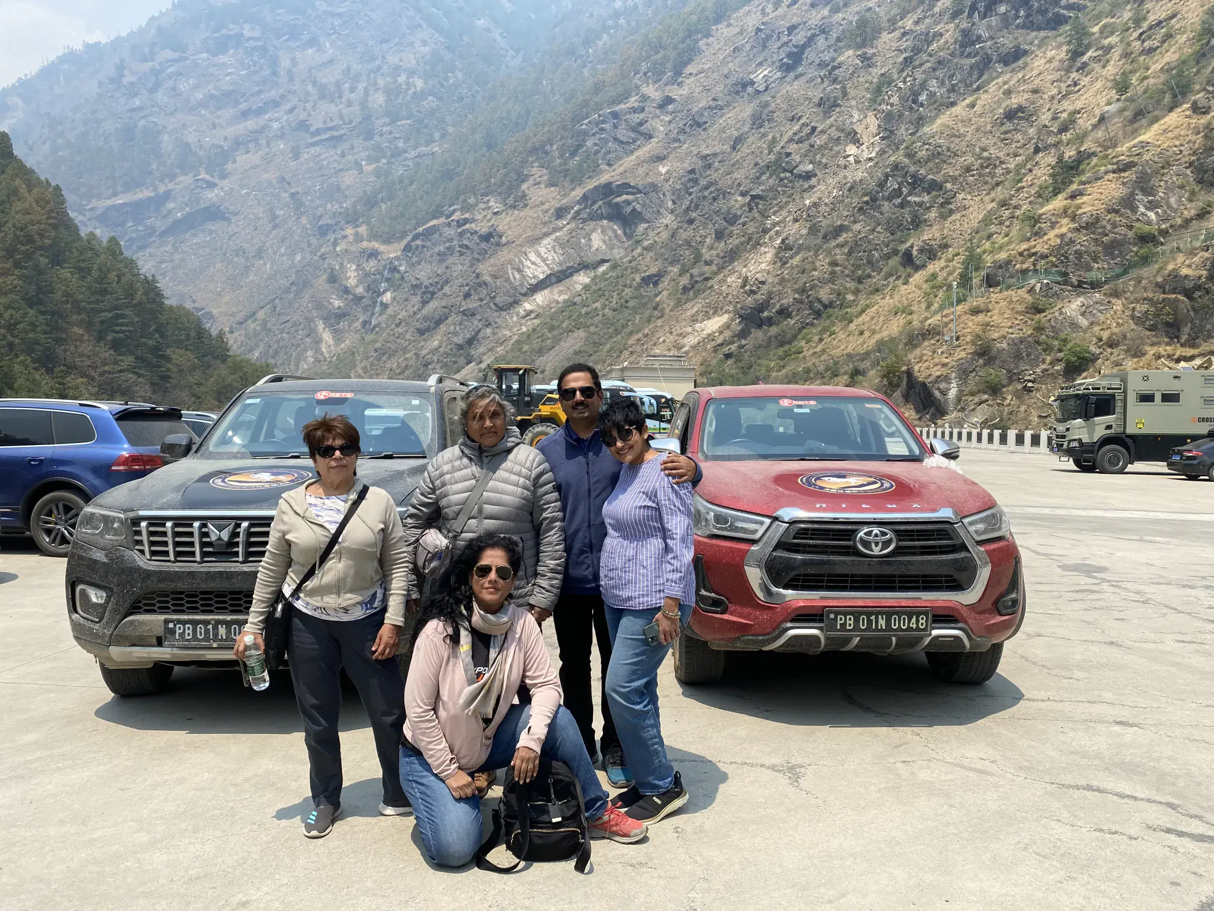 Outdoor adventure scene featuring people, a vehicle, and rocky terrain.
