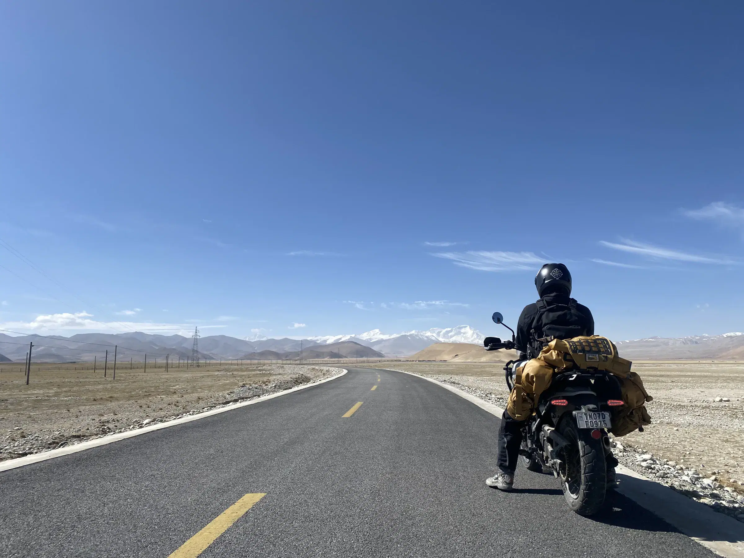 Outdoor scene featuring people, rocky terrain, and cloudy sky.