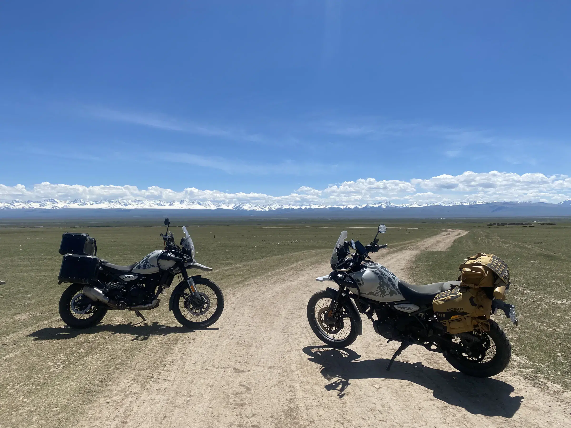 Outdoor adventure scene featuring people, a vehicle, cloudy sky, and greenery.