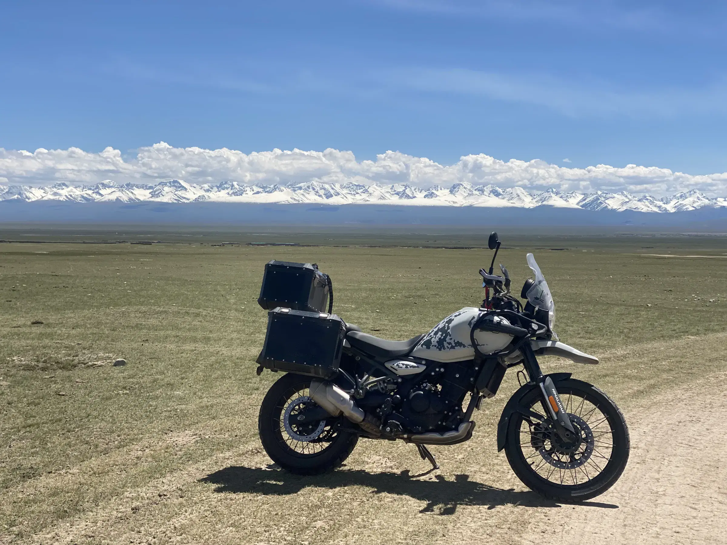 Green outdoor landscape featuring water and cloudy sky.