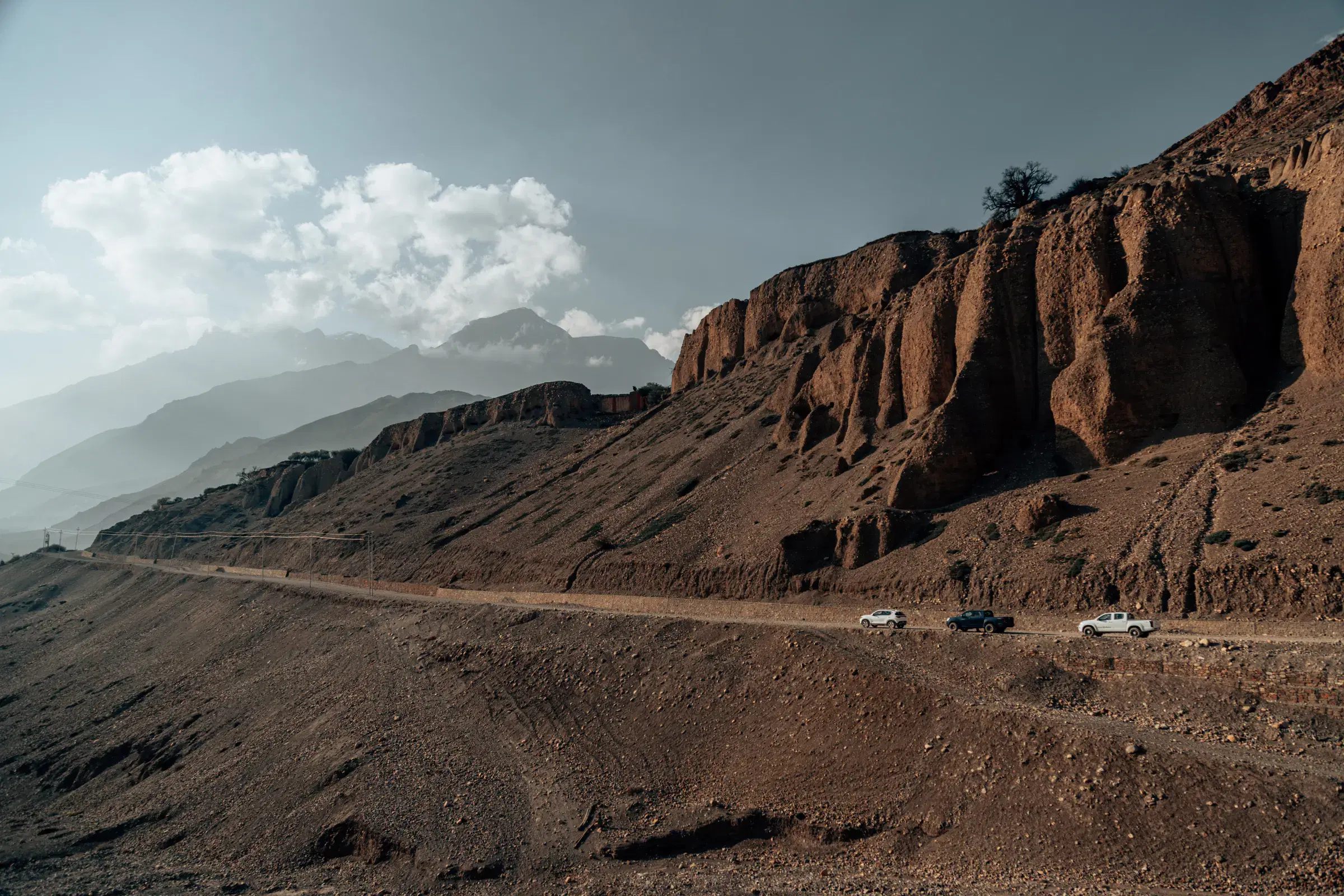 Mountain landscape featuring rocky terrain, a built structure, and cloudy sky.